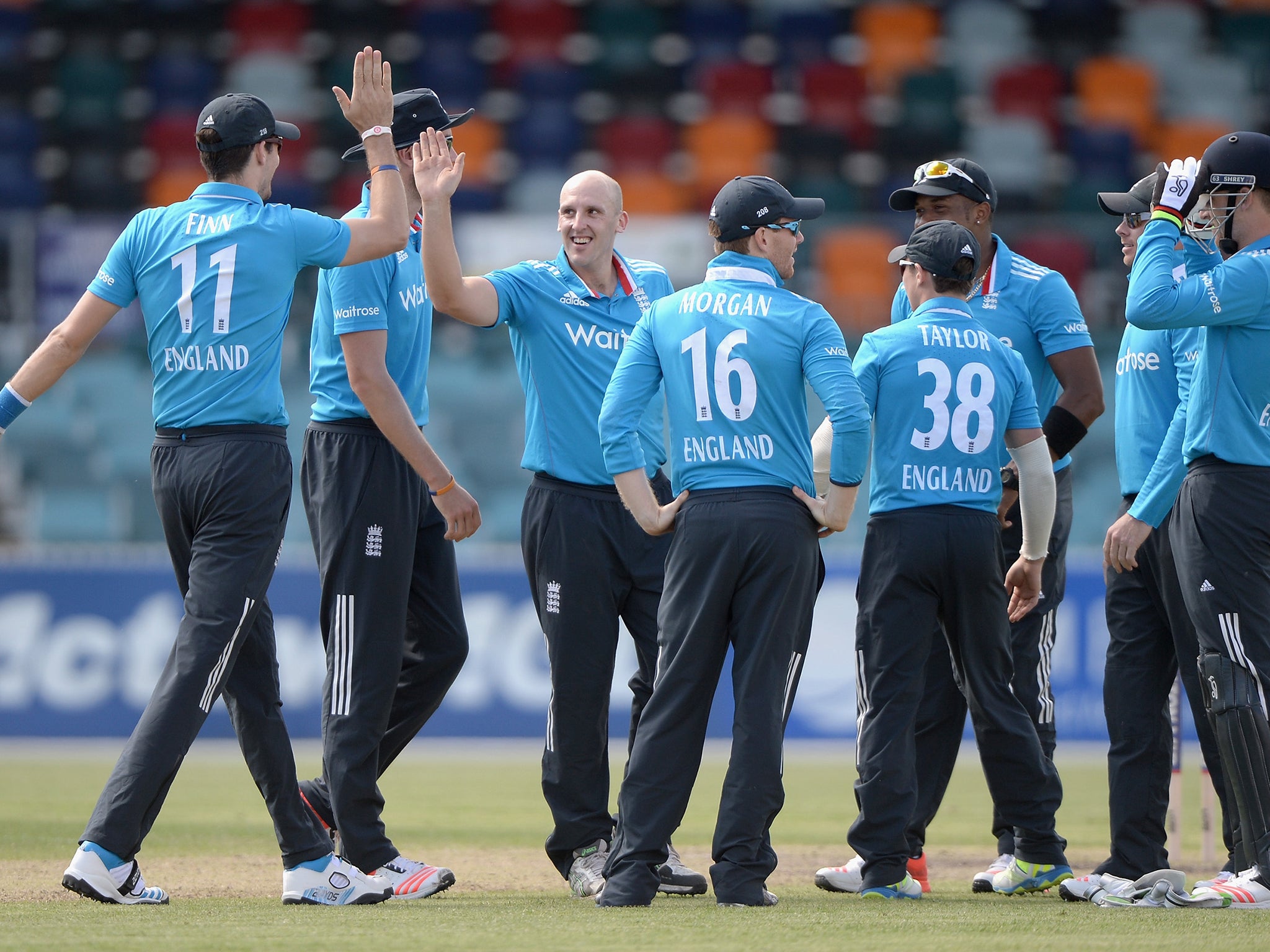 James Tredwell of England celebrates with teammates after dismissing Vele Dukoski of ACT XI