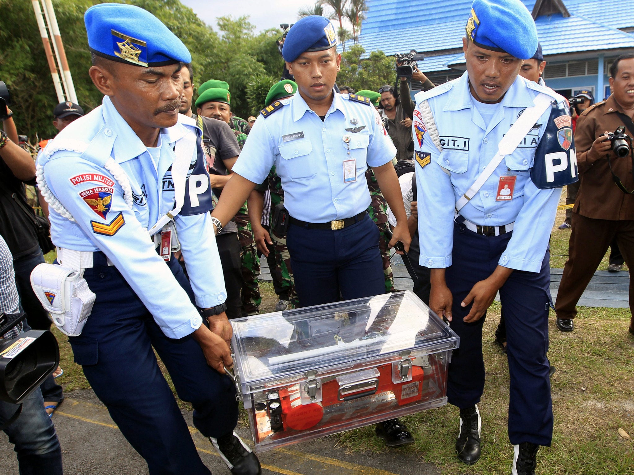 Indonesian Air Force military police officers carry the flight data recorder in a savety case after its recovery