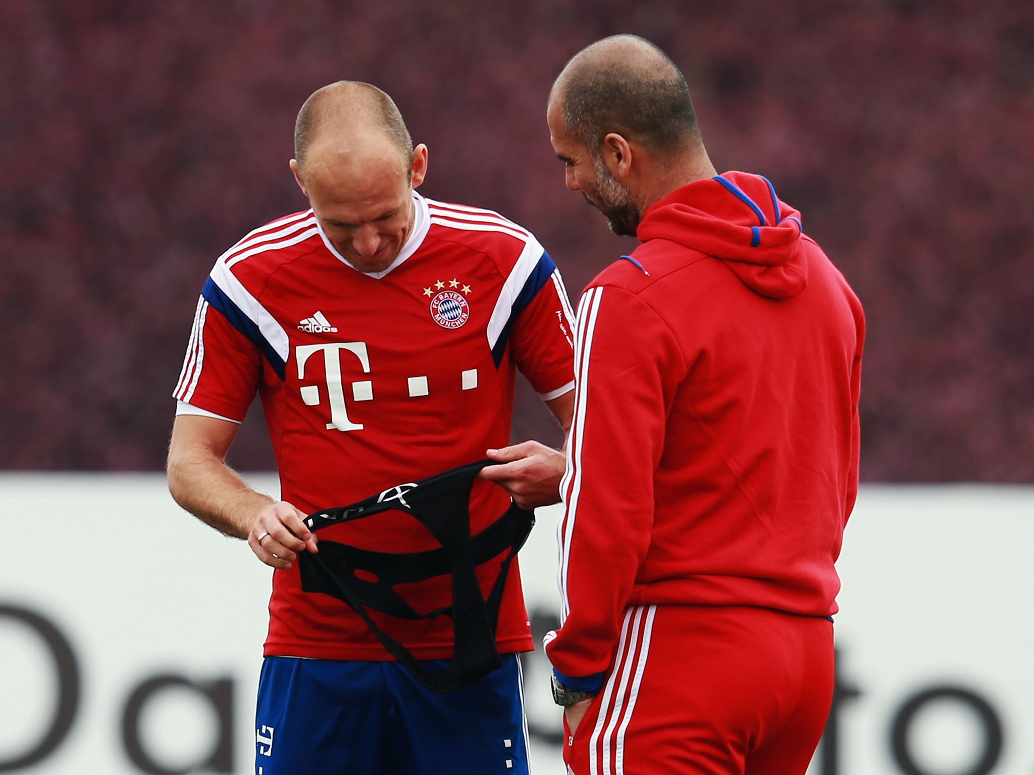 Head coach Pep Guardiola talks to Arjen Robben in Doha