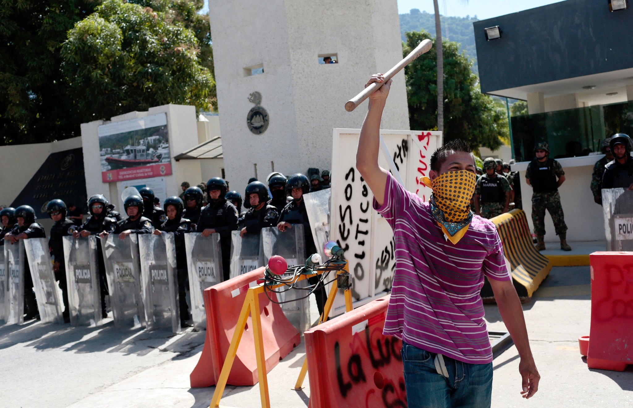 A masked man remains during a protest demanding justice and clarification of the disappearance of 43 students from Ayotzinapa, on January 12, 2015, at the naval base in Acapulco, Guerrero State, Mexico.