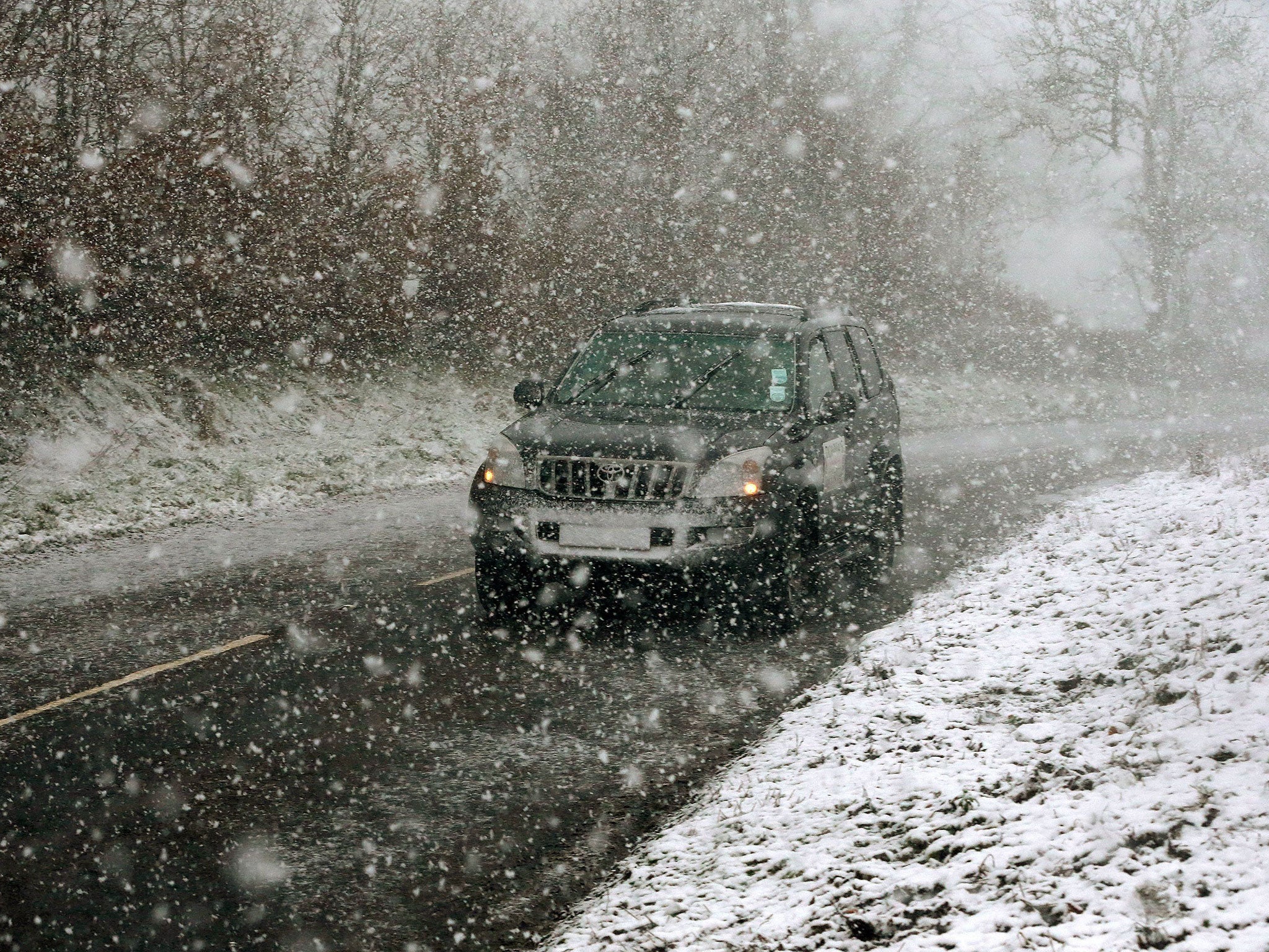 A car makes its way through snowfall in Gortin near Omagh