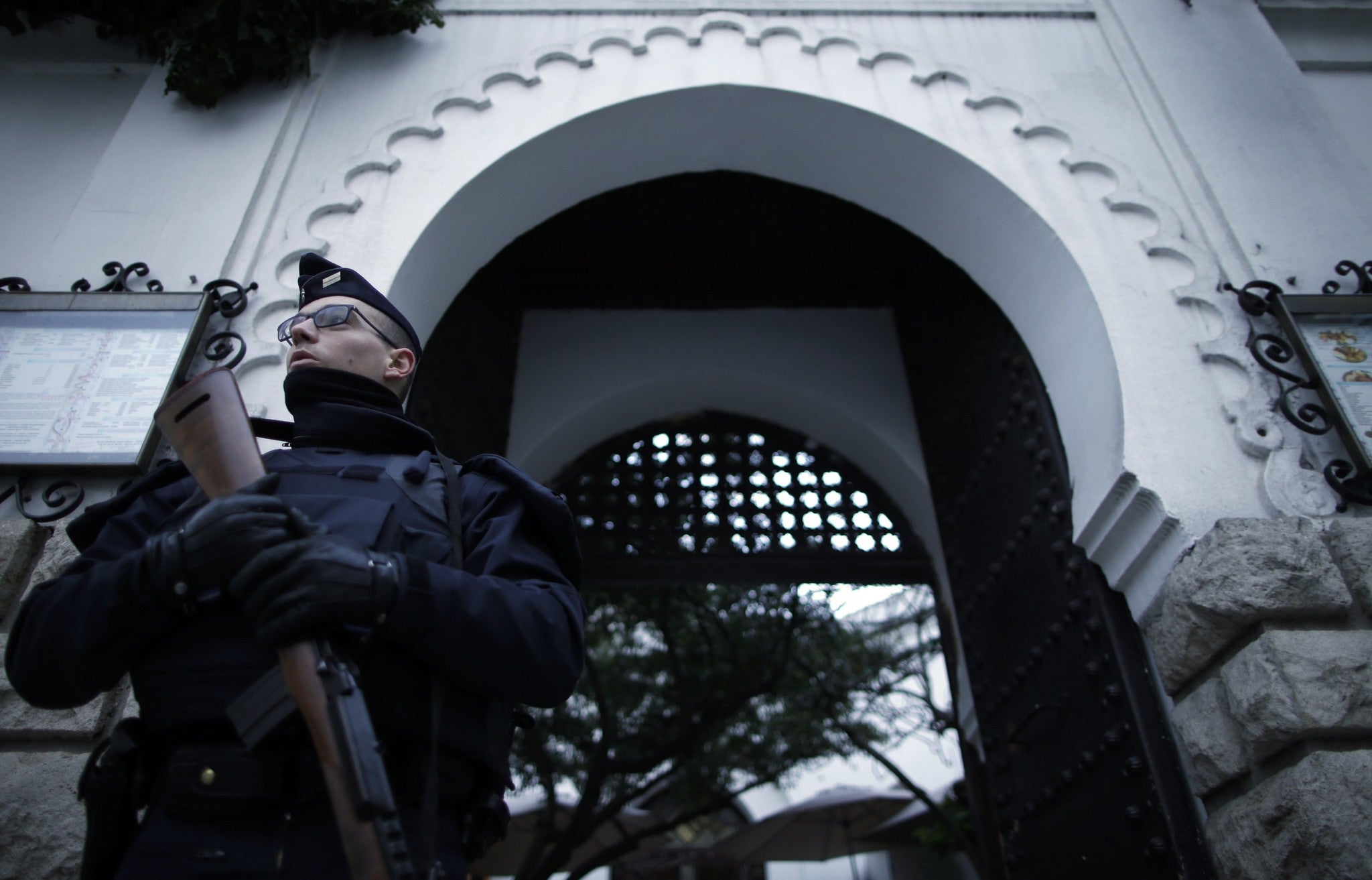 A French police officer stands in front of the entrance of the Paris Grand Mosque as part of the highest level of 'Vigipirate' security plan after January's attacks