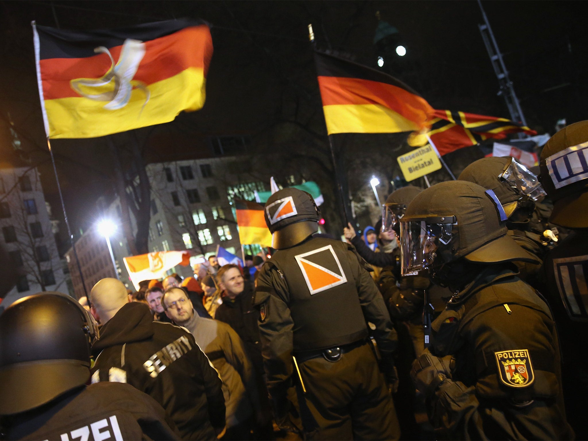 Supporters of the Pegida movement wave German flags during their protest in Dresden, Germany, on Monday (Getty)