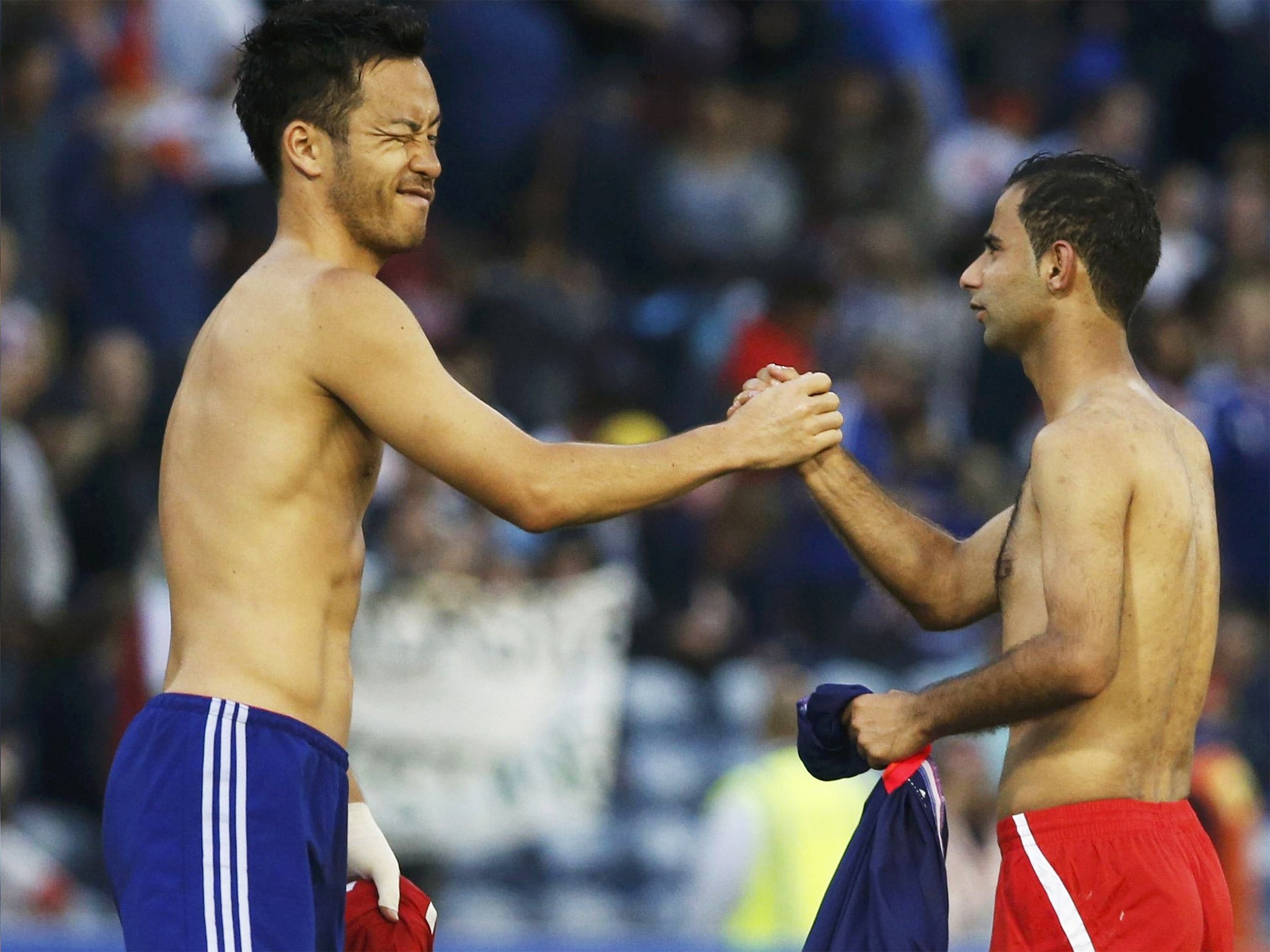 Japan’s Maya Yoshida, left, and Palestine’s Abdulhamid Abuhabib exchange jerseys following their Asian Cup match