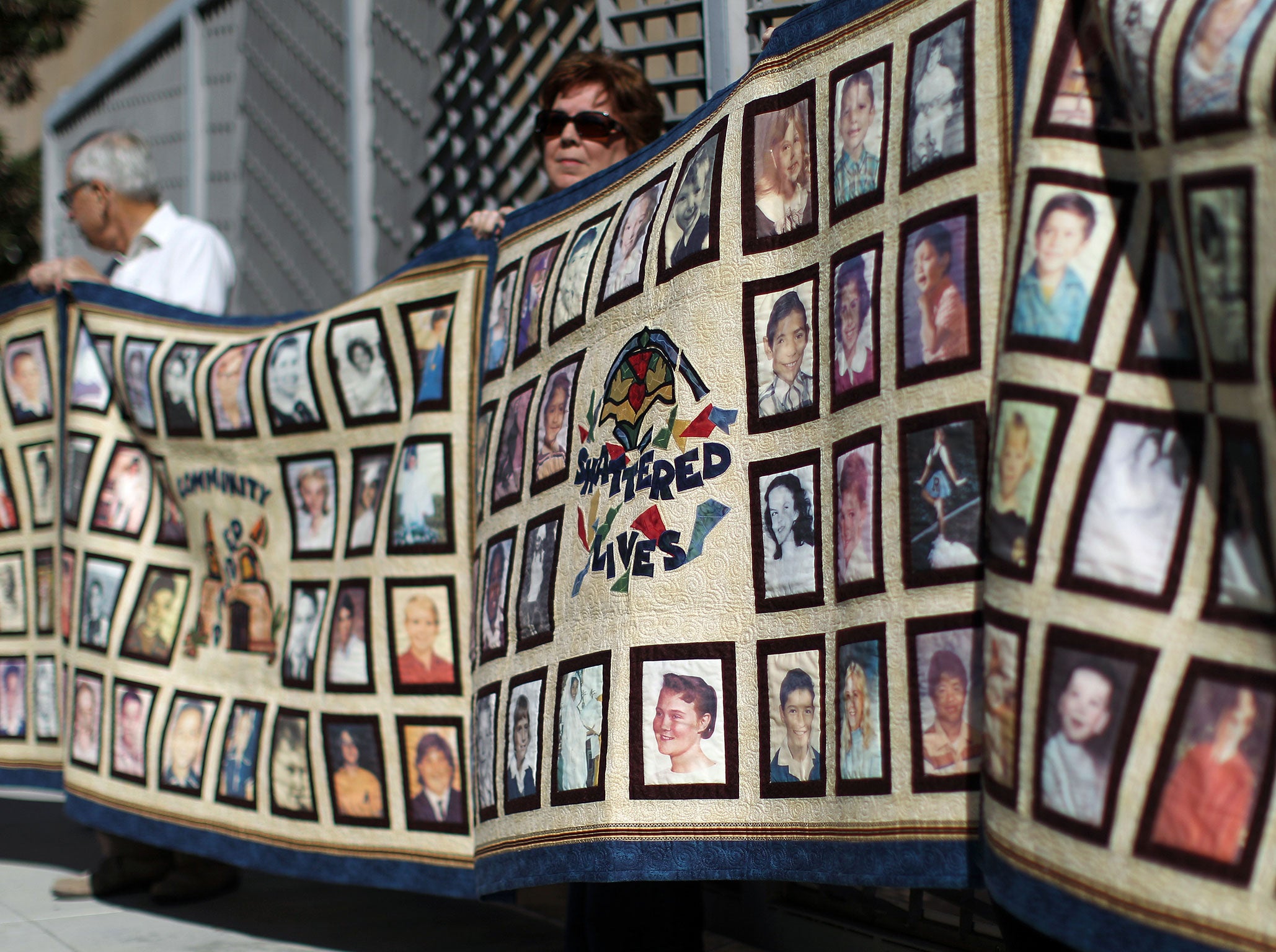 People hold quilts at a press conference outside Cathedral of Our Lady of the Angels for victims of sexual abuse by priests in Los Angeles