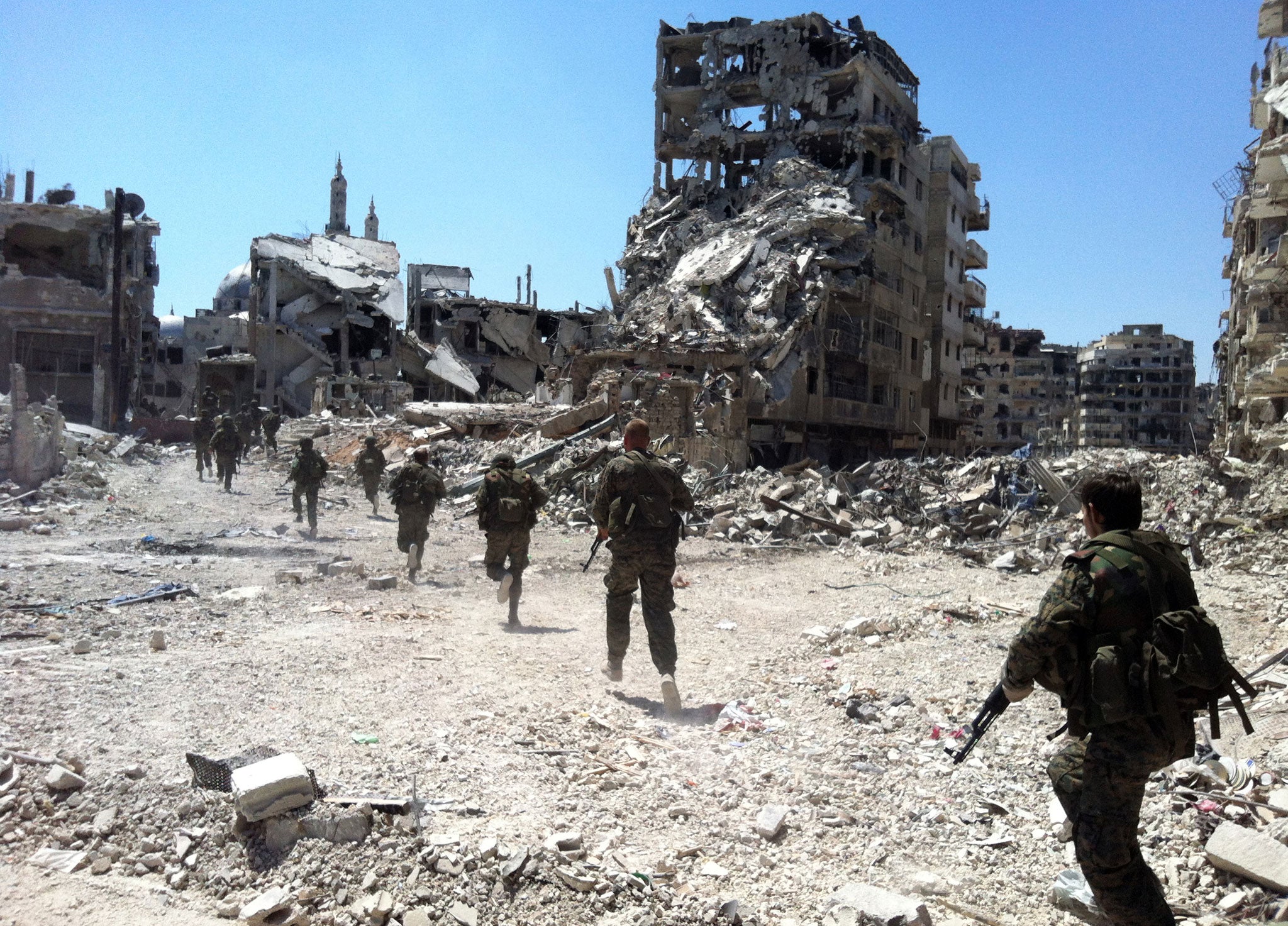 Syrian government forces patrolling in the Khalidiyah neighbourhood of the city of Homs in July 2013 (AFP)