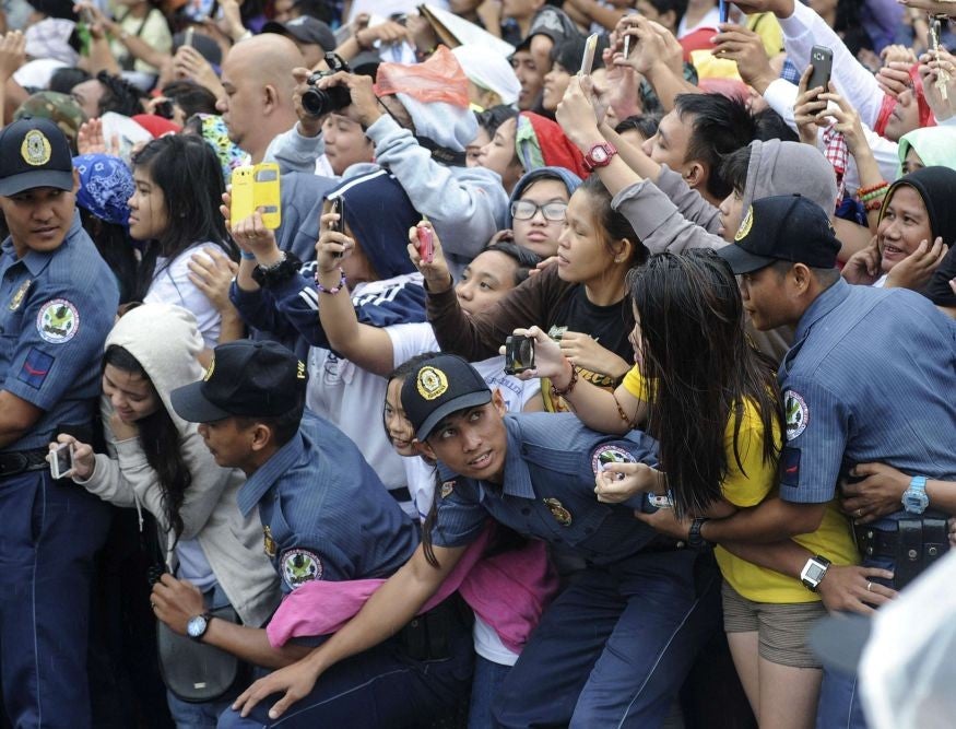 Crowds of well-wishers excited to see the Pope held back by police