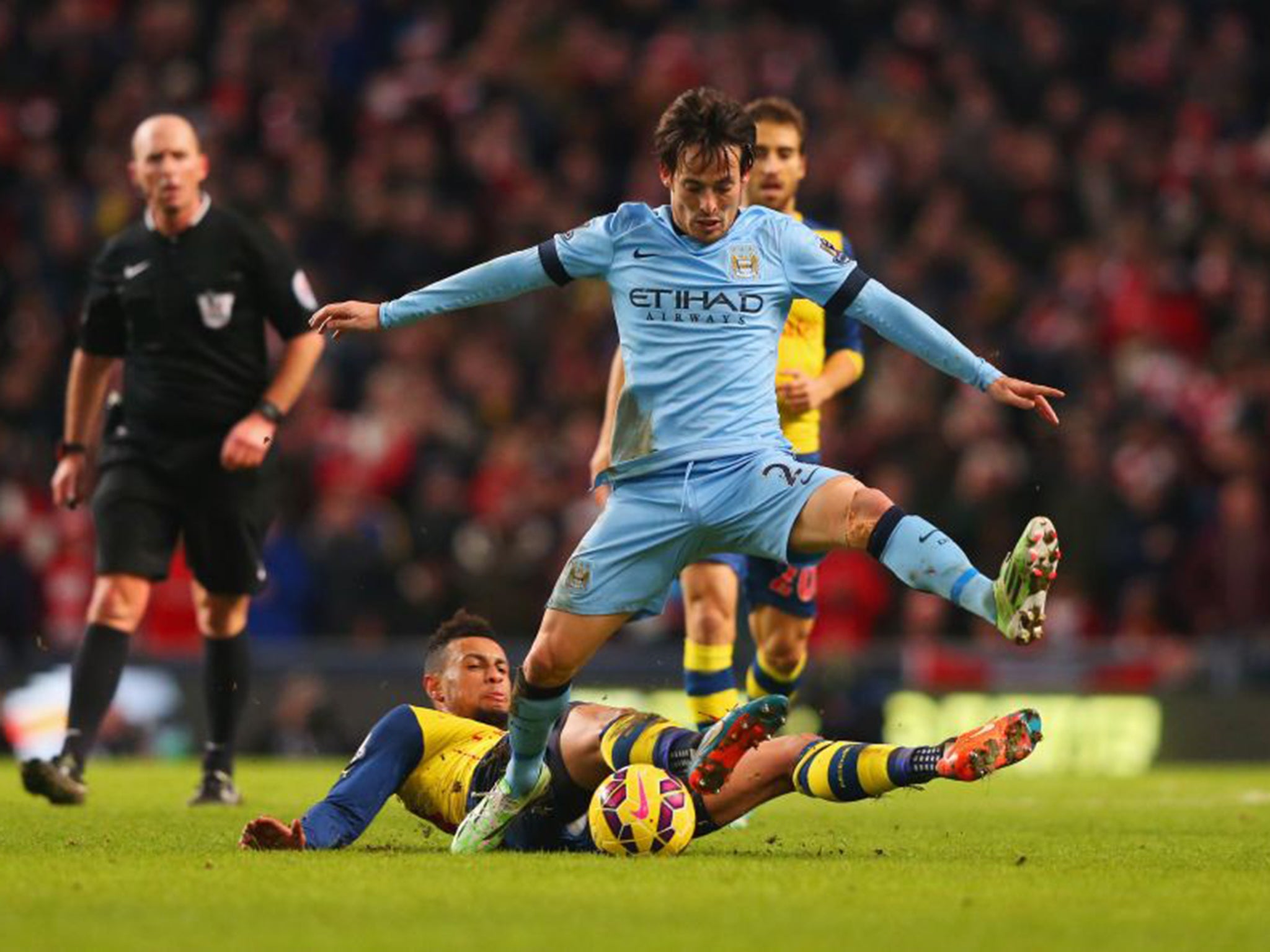 Manchester City’s David Silva is tackled by Francis Coquelin of Arsenal