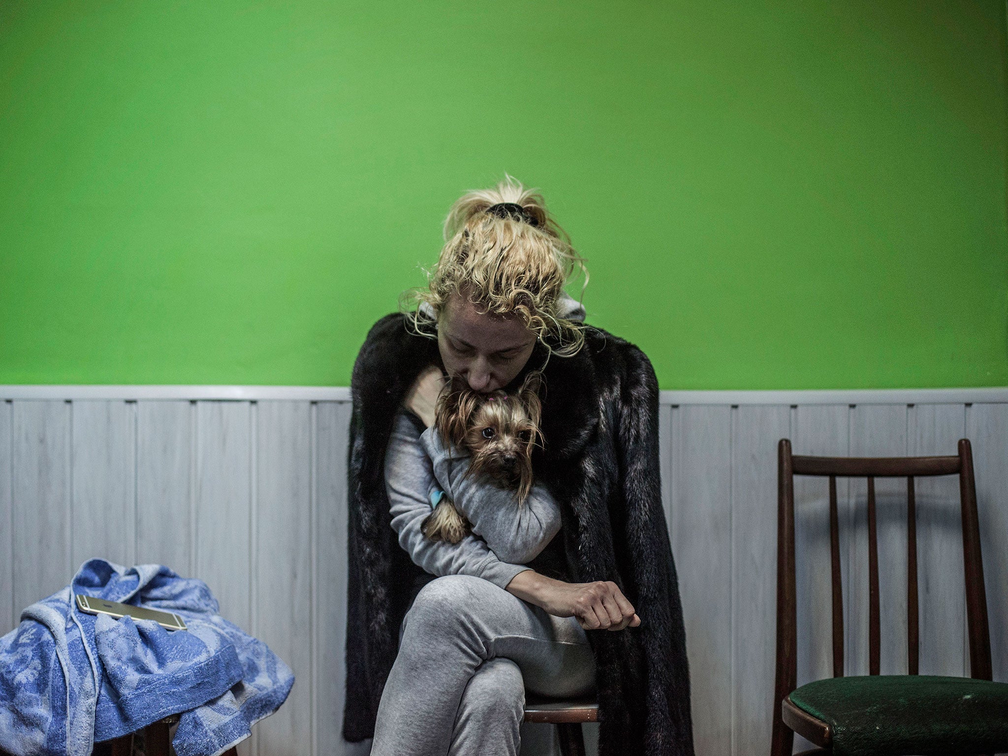 A Ukrainian woman embraces her dog in a shelter during the heaviest exchange of artillery fire in the last few days in Donetsk