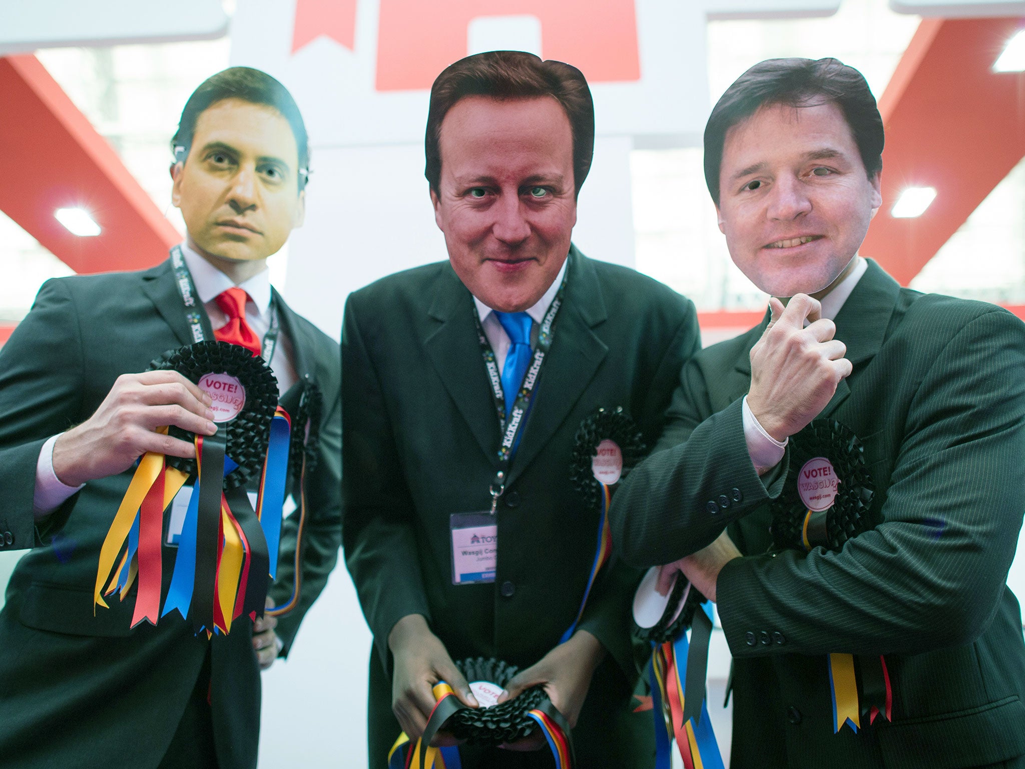 Three people wearing masks depicting Ed Miliband, David Cameron and Nick Clegg