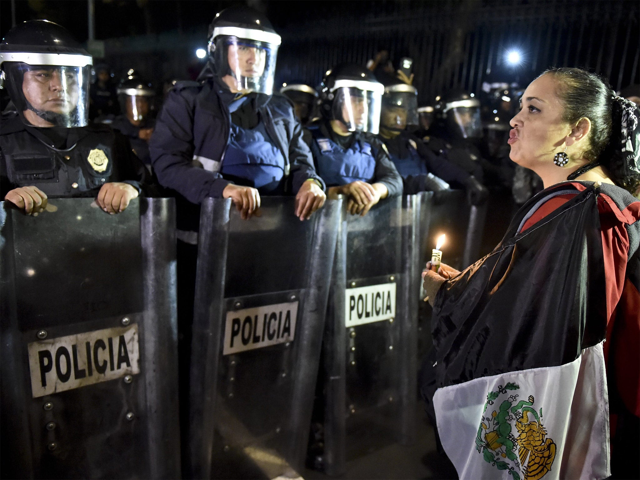 A woman protests outside the presidential palace in Mexico City to demand answers over the missing students in Guerrero state