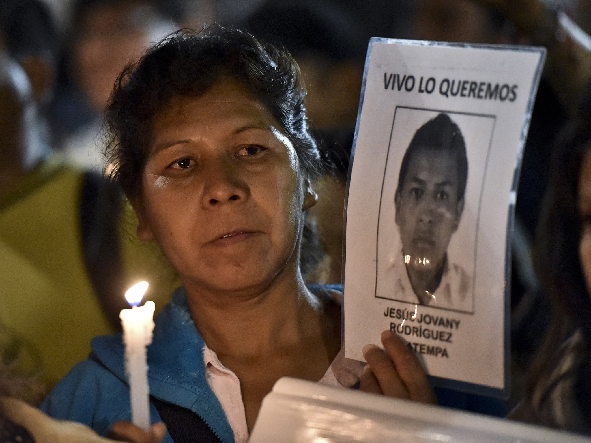 A woman holds a portrait of her missing son during a protest outside the heavily guarded Los Pinos Presidential palace