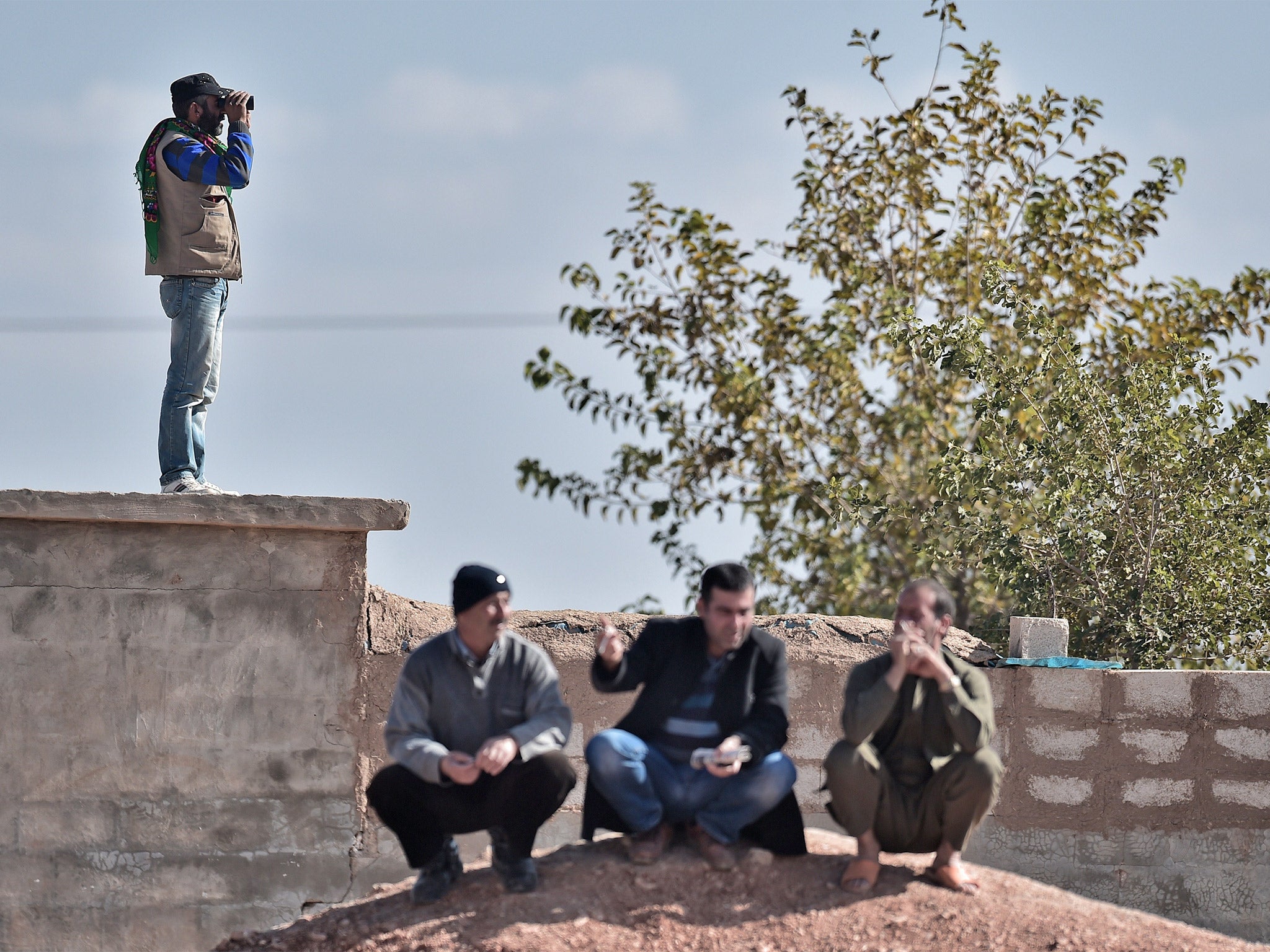 Kurdish men in the Turkish border village of Mursitpinar, overlooking the besieged Syrian city of Kobane in November last year