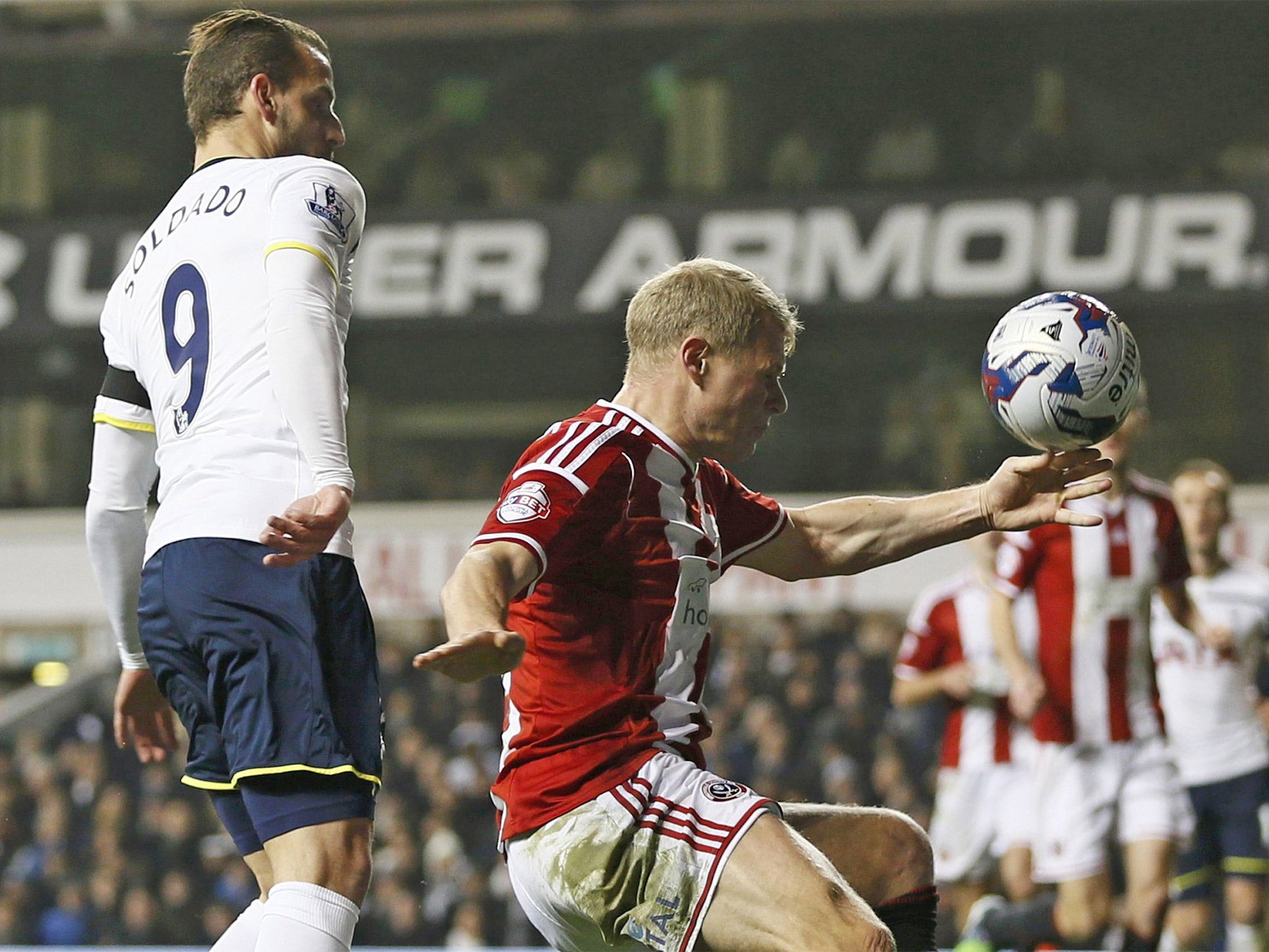 Jake McEveley handles the ball in the area to give Tottenham a penalty