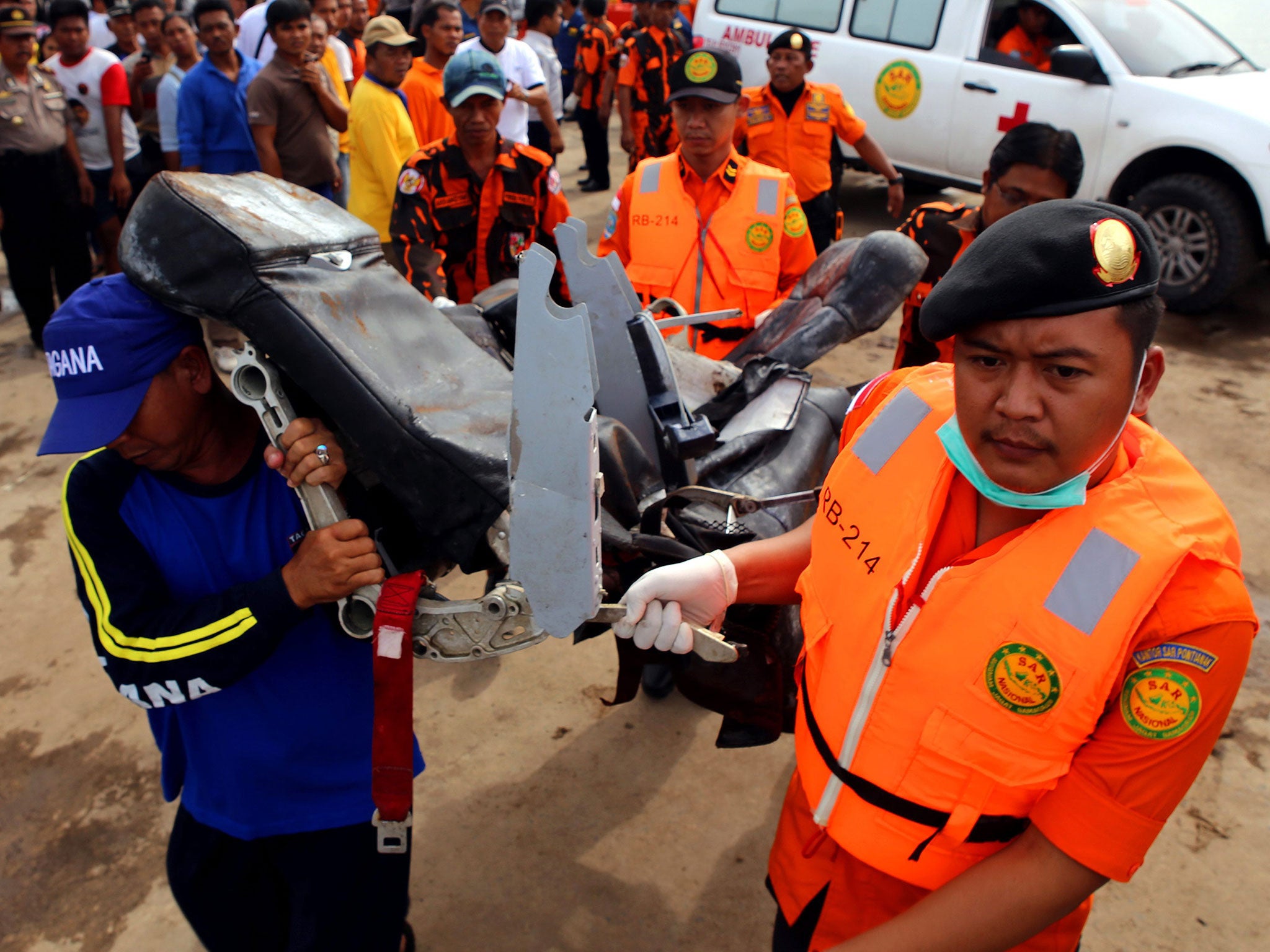 Indonesian rescue personnels carry a wrecked seat of the AirAsia Flight QZ8501