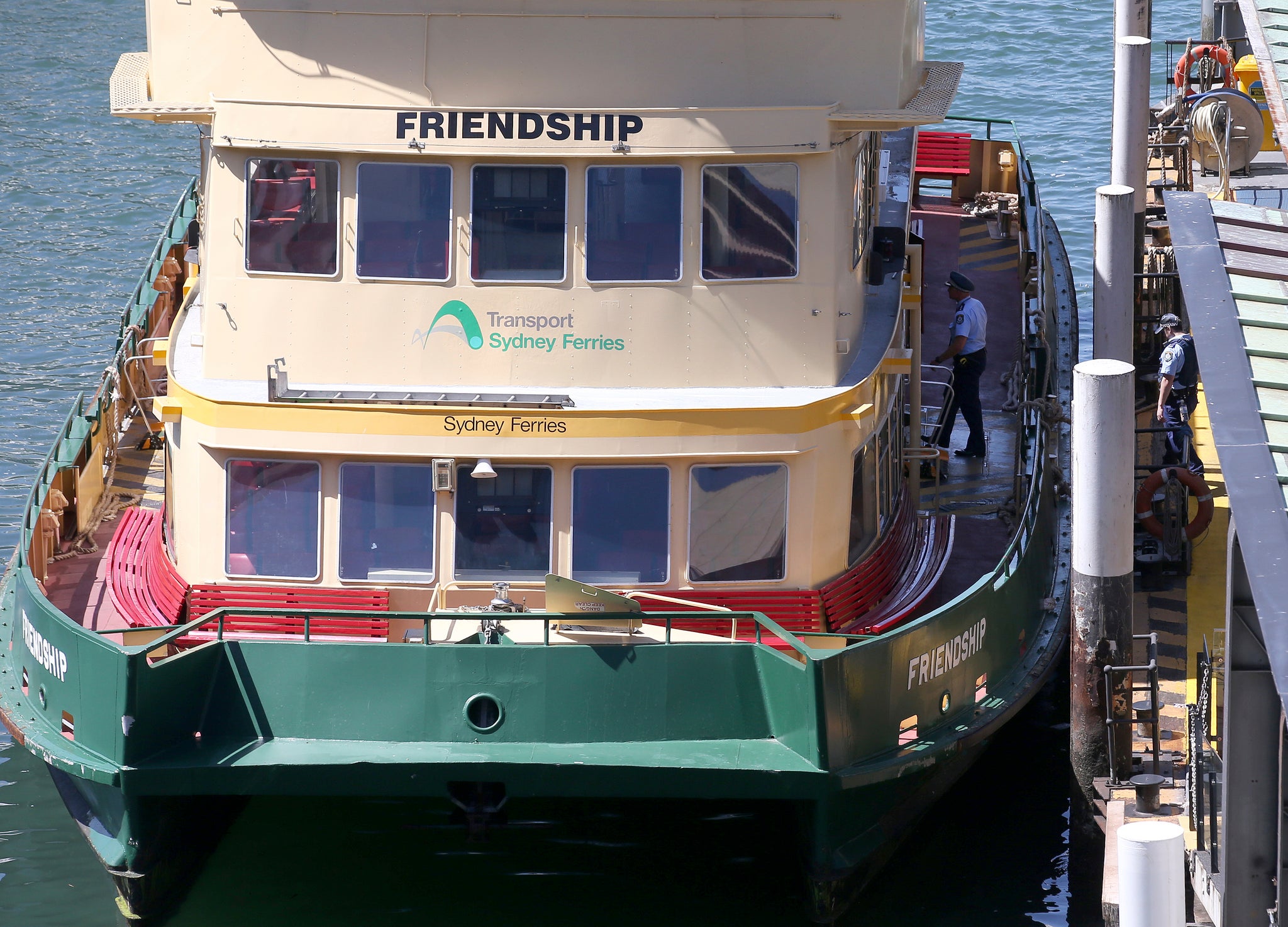 Police officers walk on to a ferry following a bomb scare on Sydney Harbour
