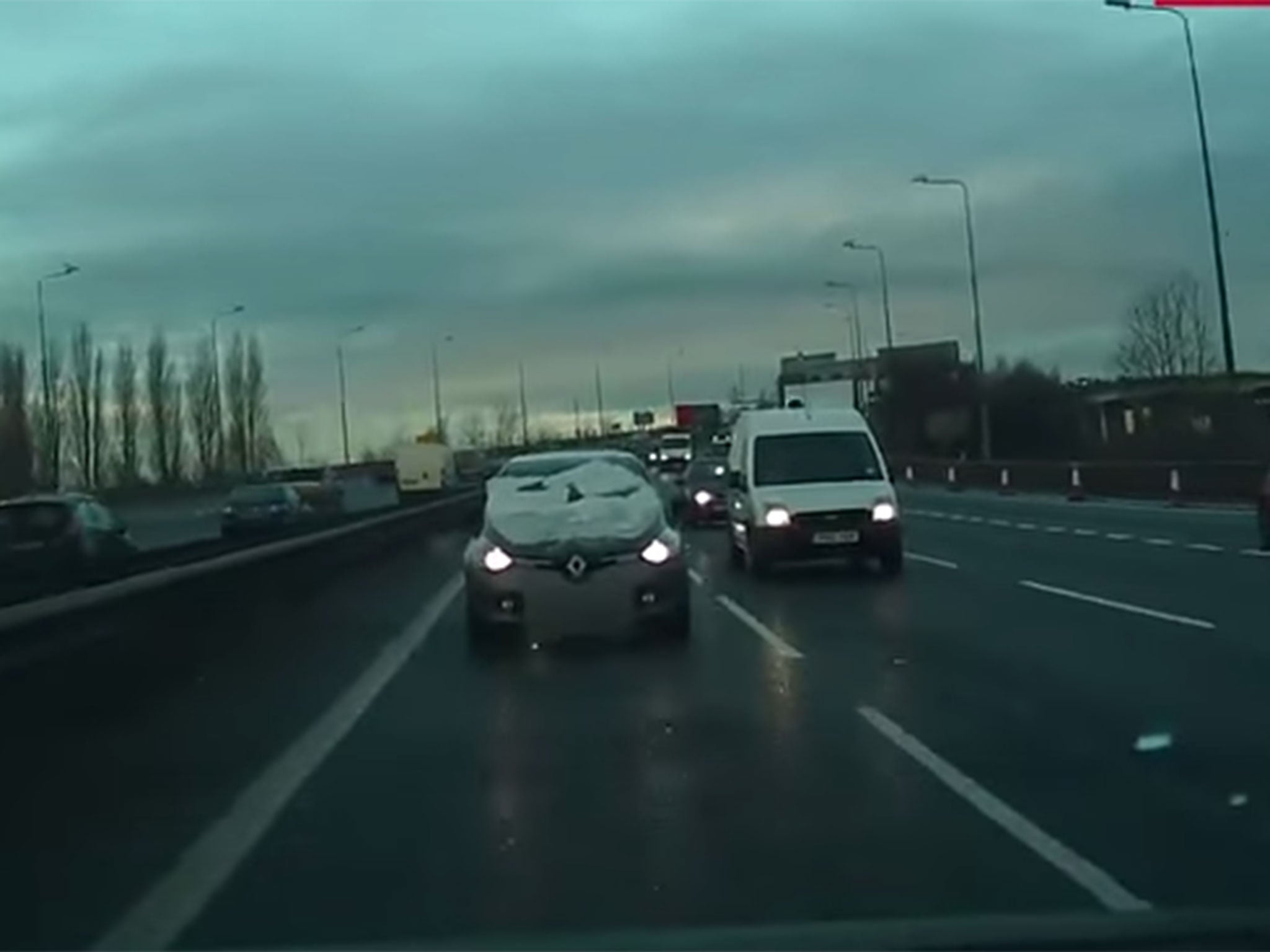 The snow-covered car was captured by a fellow motorist's dashcam on Monday