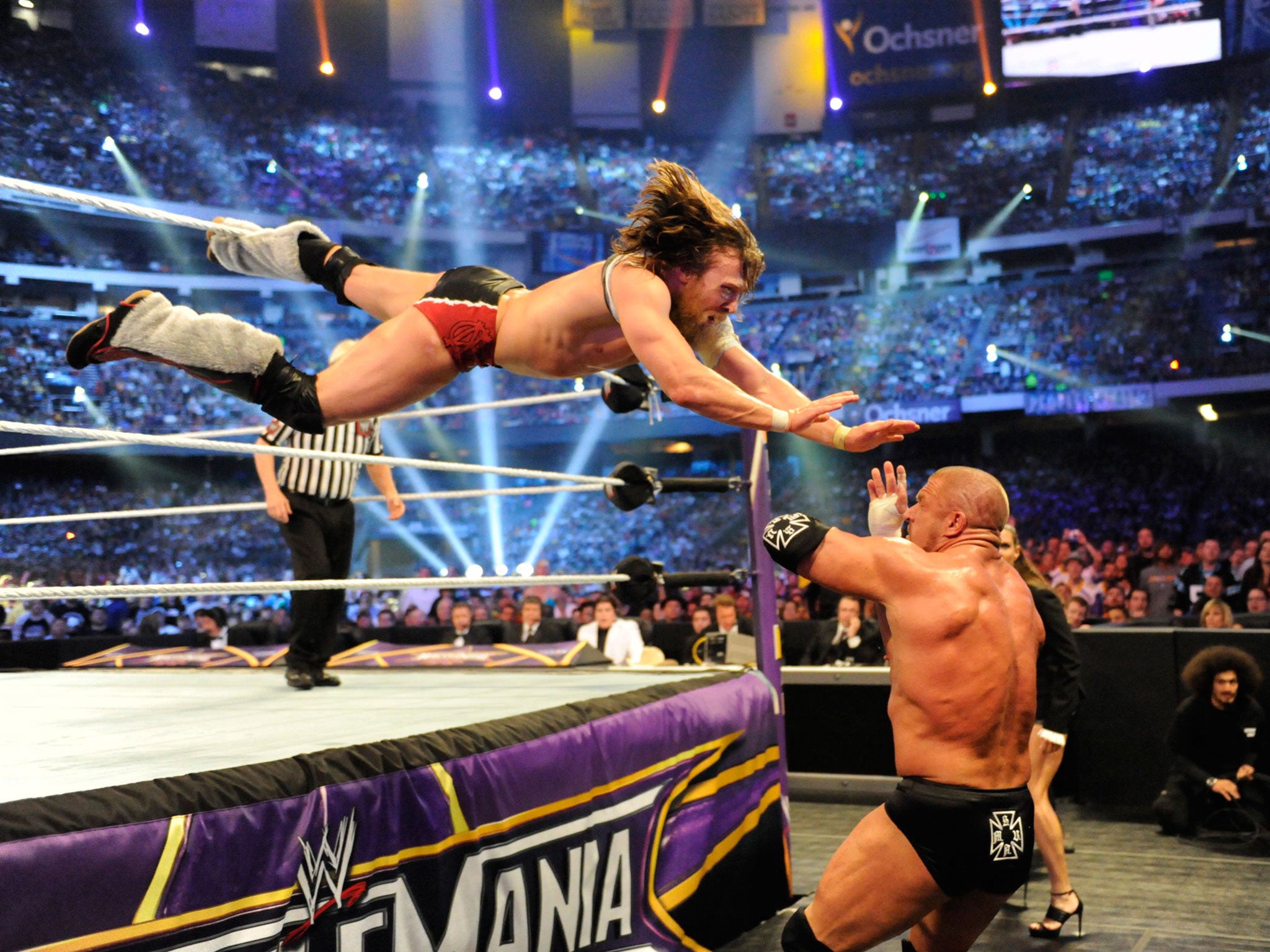 Daniel Bryan leaps out onto Triple H during their match at Wrestlemania 30