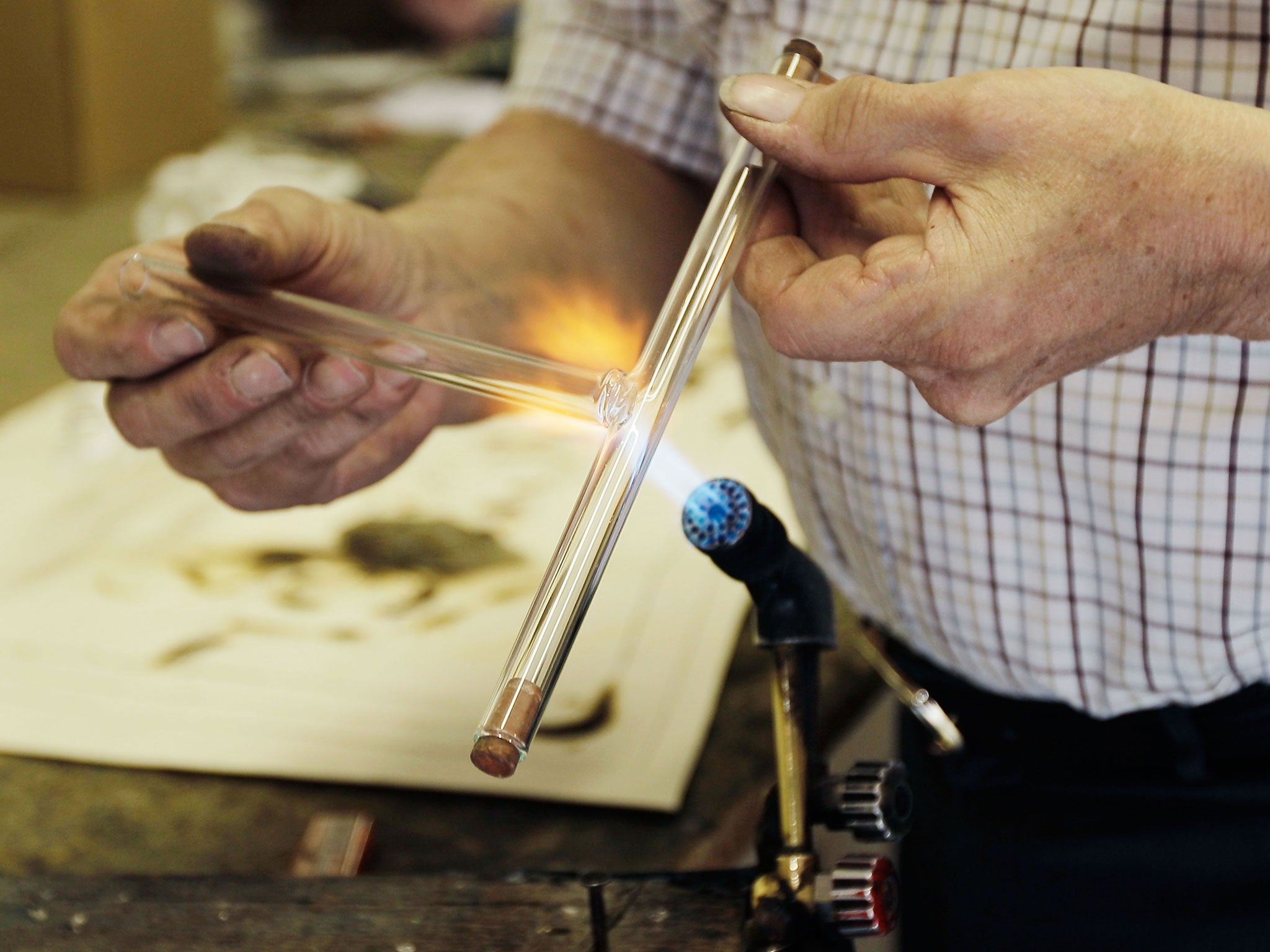 A craftsman making a neon light: energy takes up a large proportion of the costs of small firms