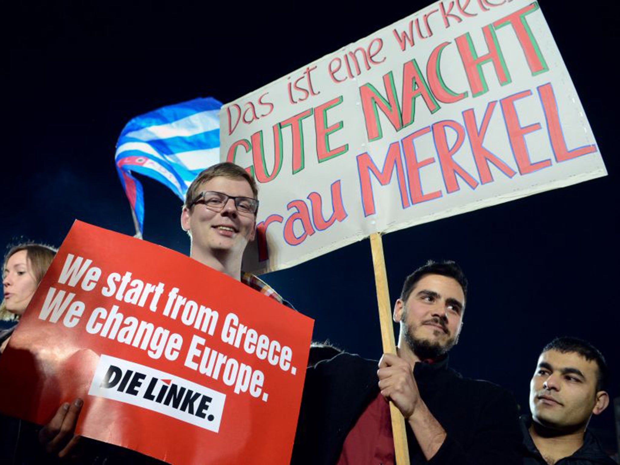 Supporters of the left-wing Syriza party in Athens hold a placard that reads: "This is a really good night Mrs Merkel"