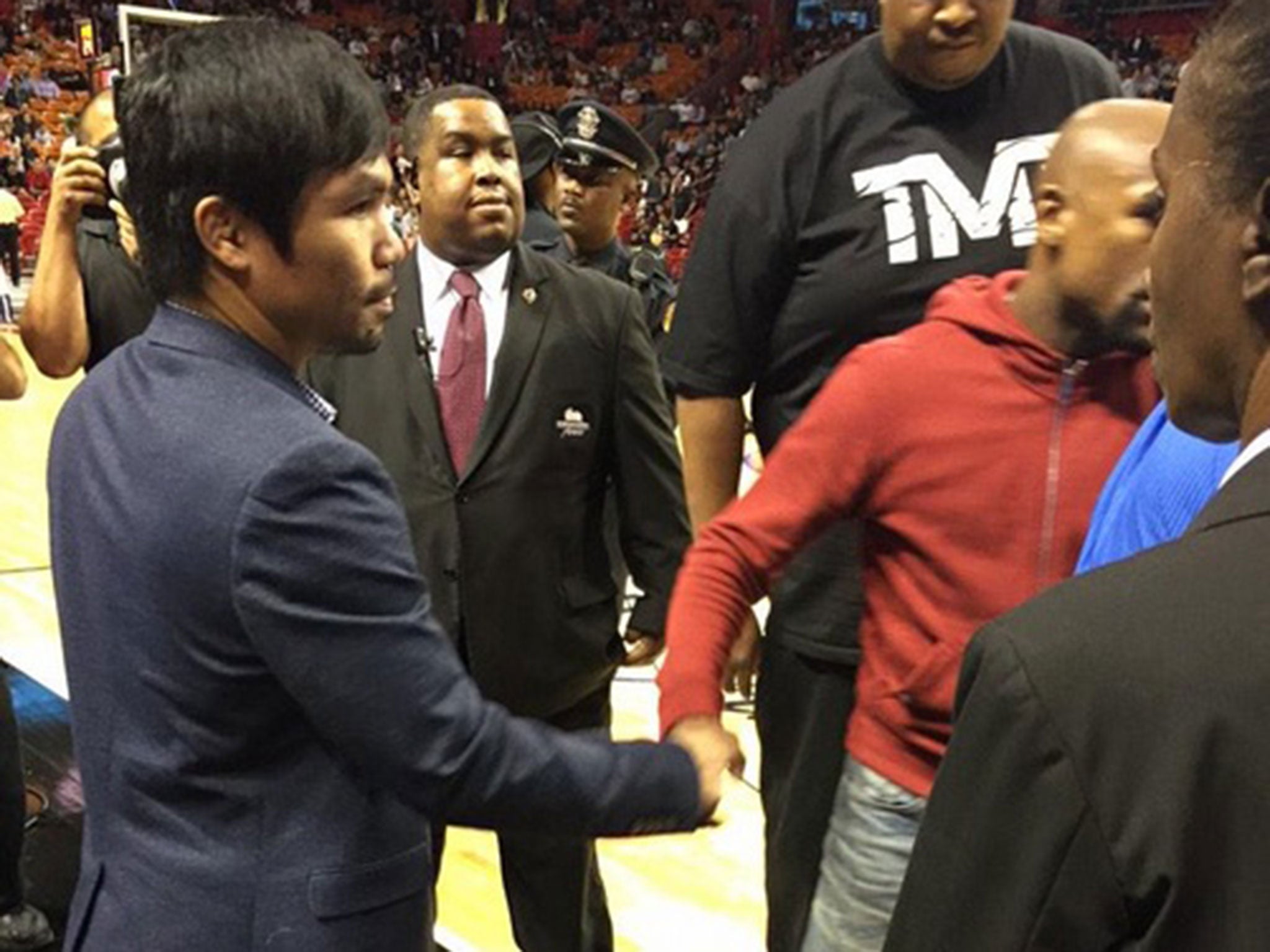 Pacquiao and Mayweather shake hands at a Miami Heat game