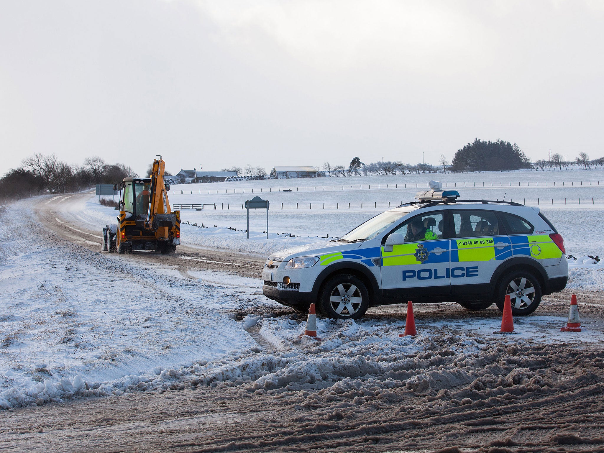 A police car and JCB on the closed A68 near Consett, County Durham