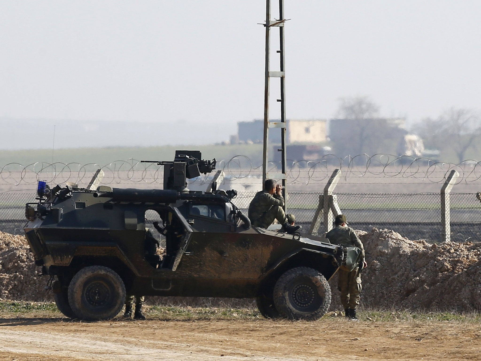 Turkish soldiers monitor the border line as they stand guard near the Akcakale border crossing in Sanliurfa province, southeastern Turkey