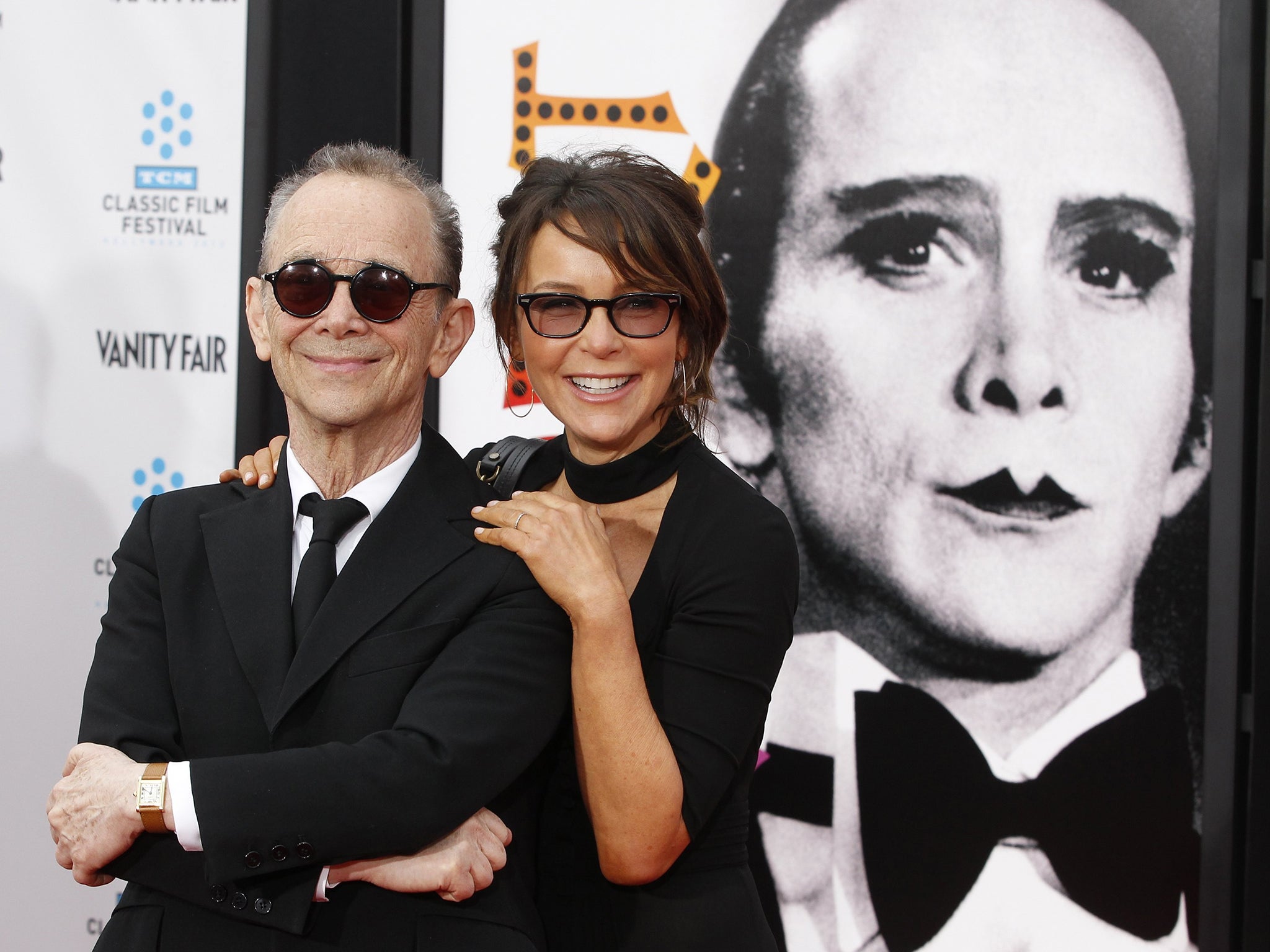 Joel Grey (left) poses next to a poster featuring his character in the film "Cabaret"