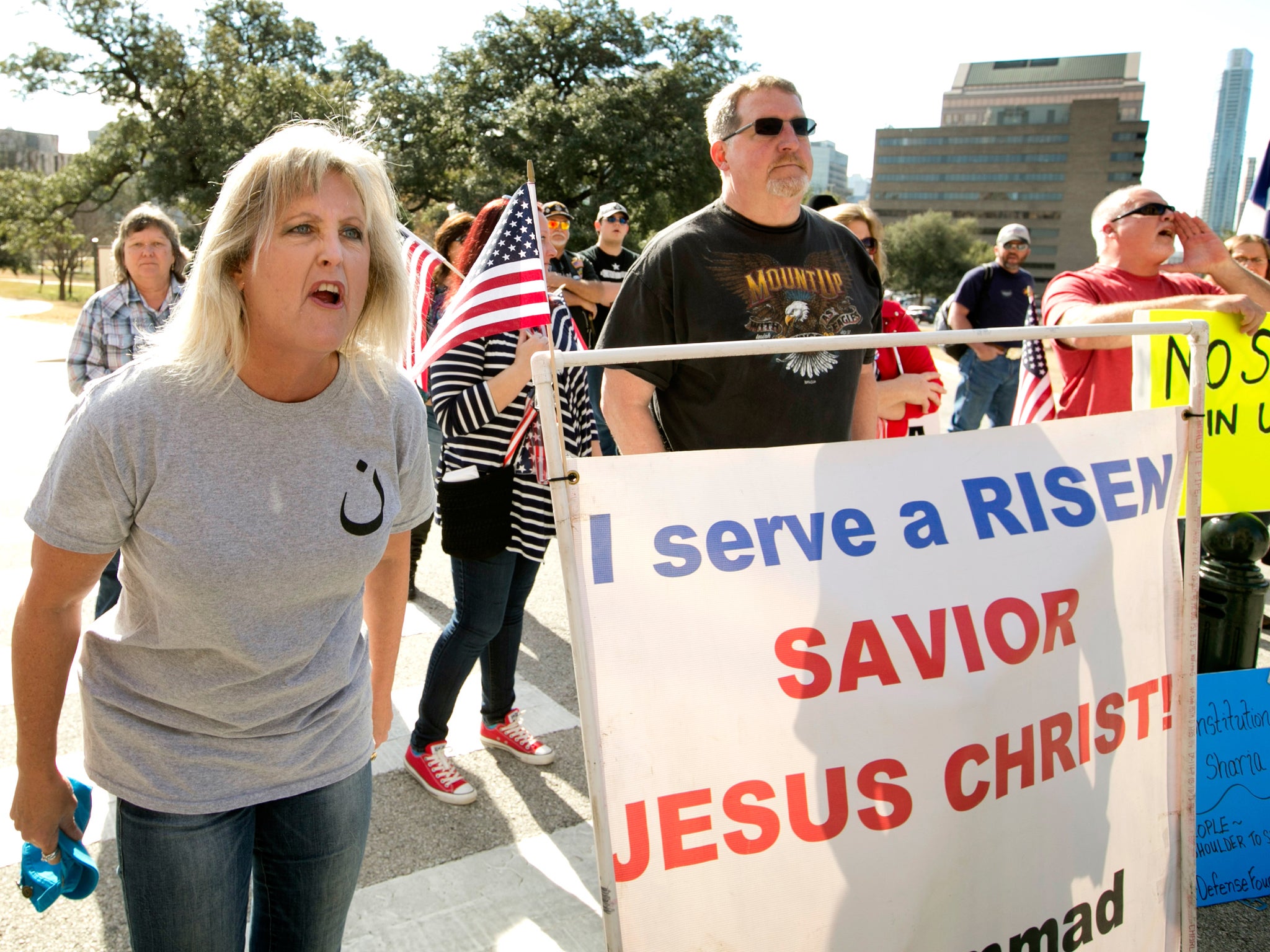 A protester waves the Israeli flag at the Texas Capitol as a group gathers for a Texas Muslim Capitol Day rally in Austin