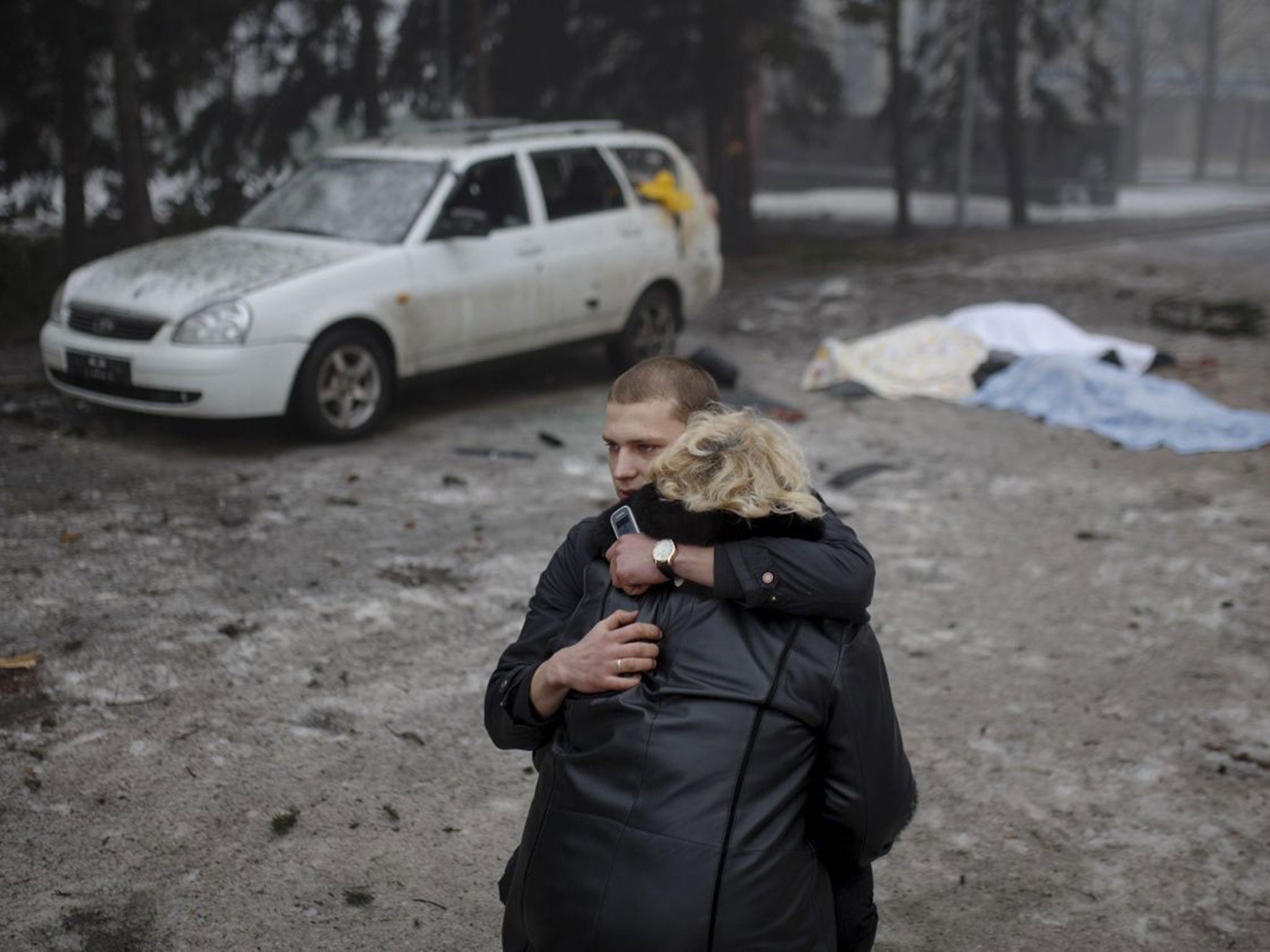 A rebel comforts a wife of a killed civilian in shelling in Donetsk, eastern Ukraine