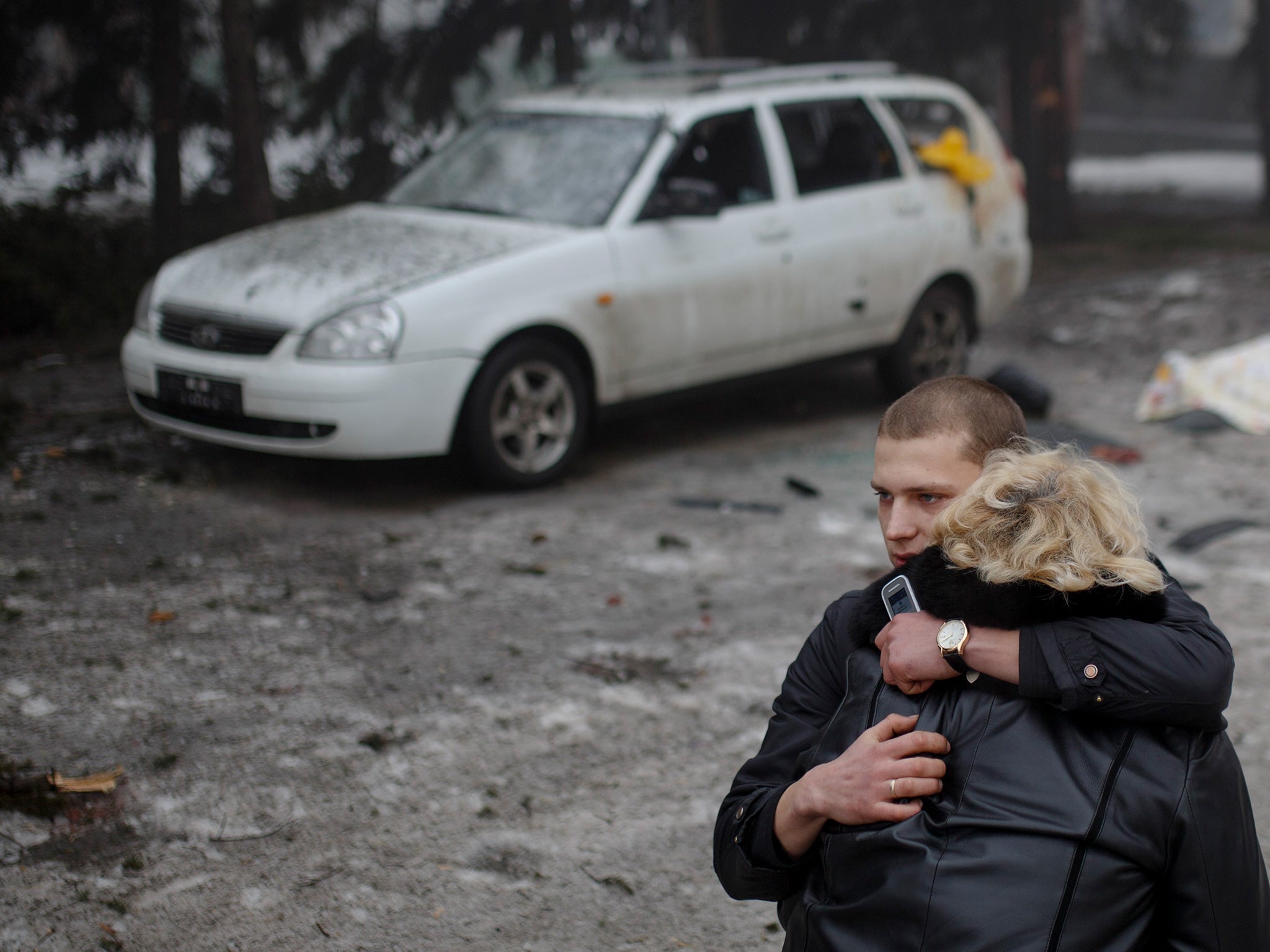 A rebel comforts a wife of a killed civilian in shelling in Donetsk