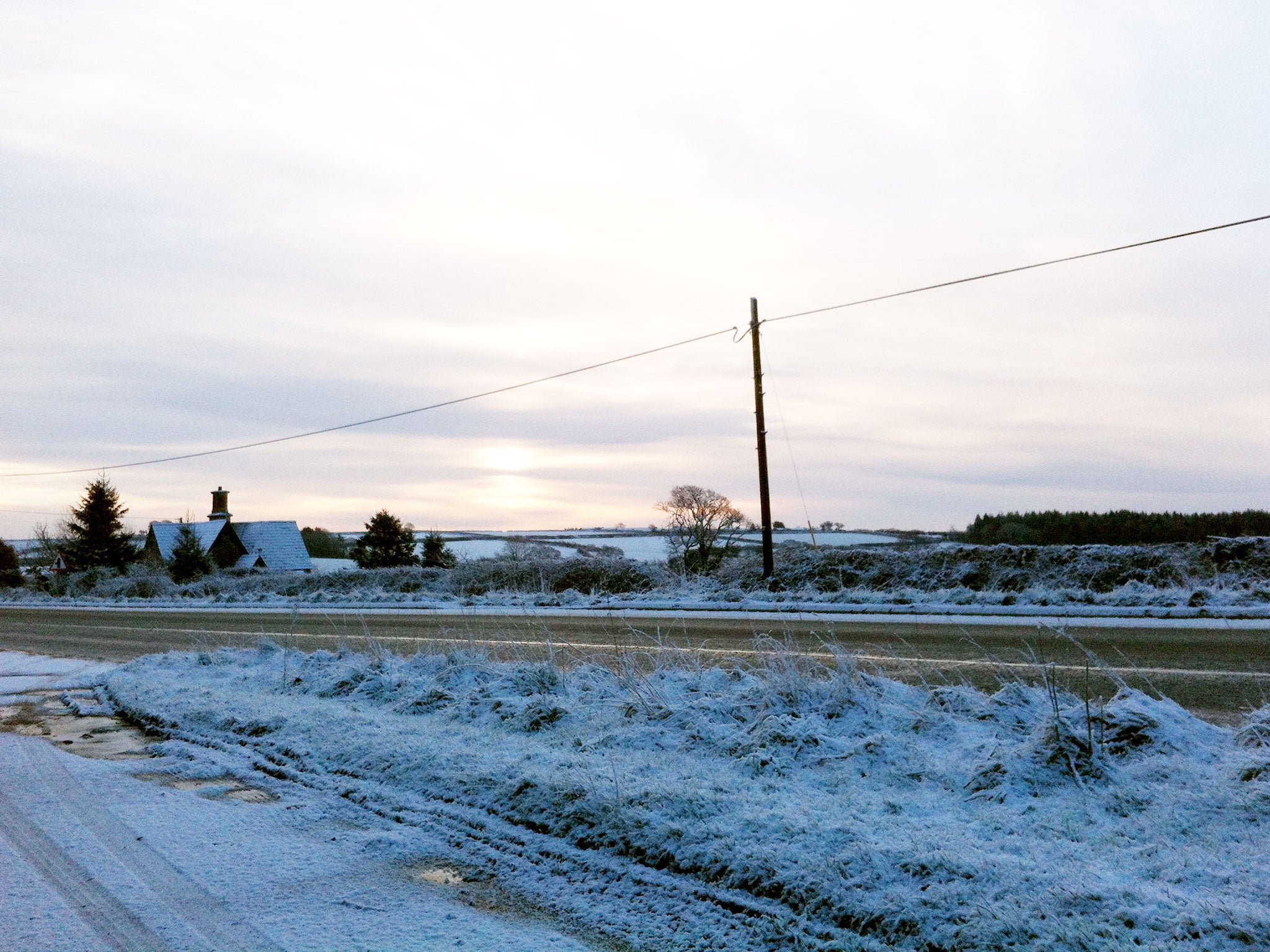 The sun breaks through the clouds over a snow covered Bodmin Moor in Cornwall