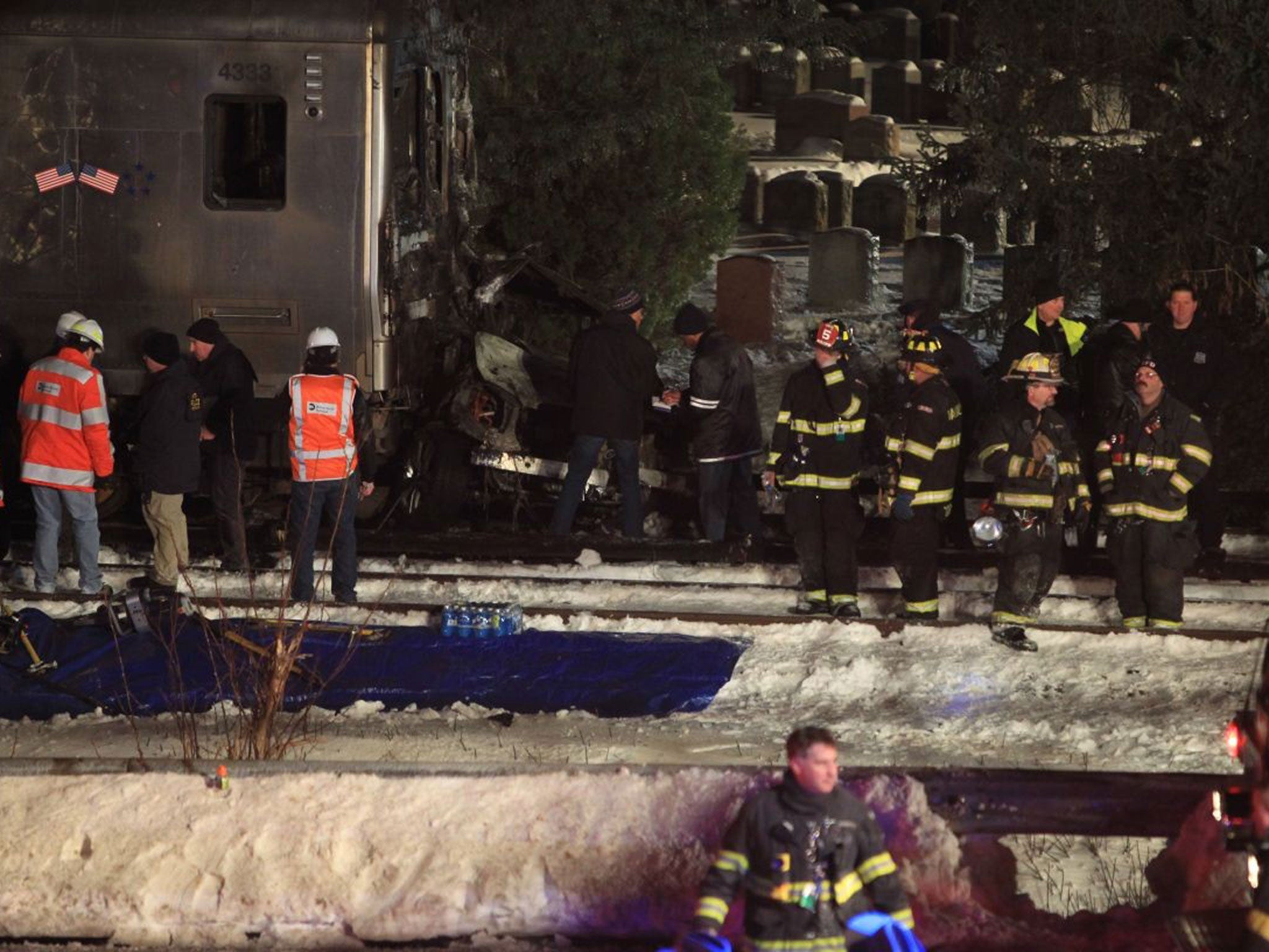 Emergency personnel work at the scene of a Metro-North Railroad passenger train and a vehicle accident in Valhalla, New York