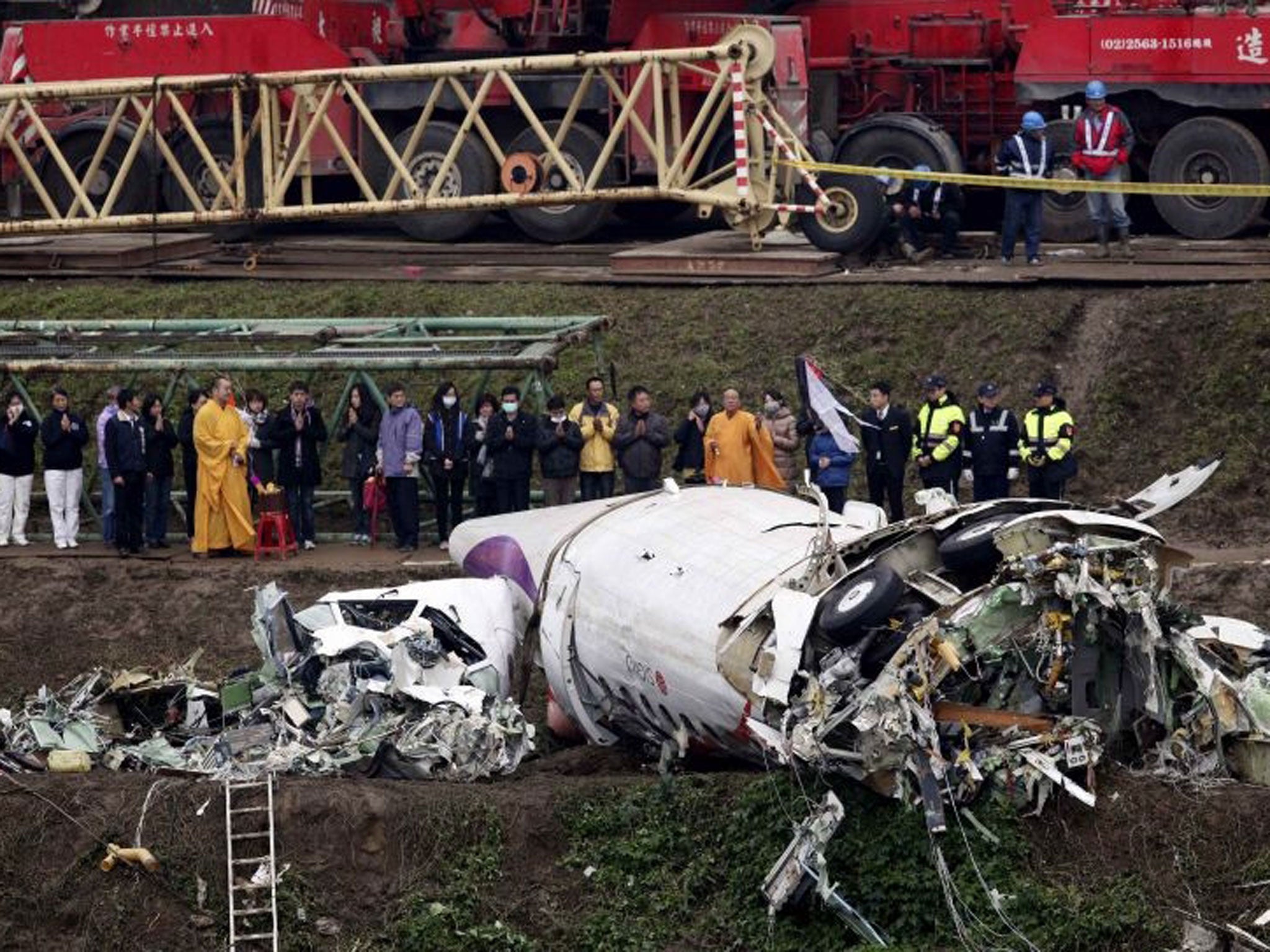 Relatives of the victims pray during a Buddhist ritual near the wreckage of TransAsia Airways Flight GE235 on 5 February