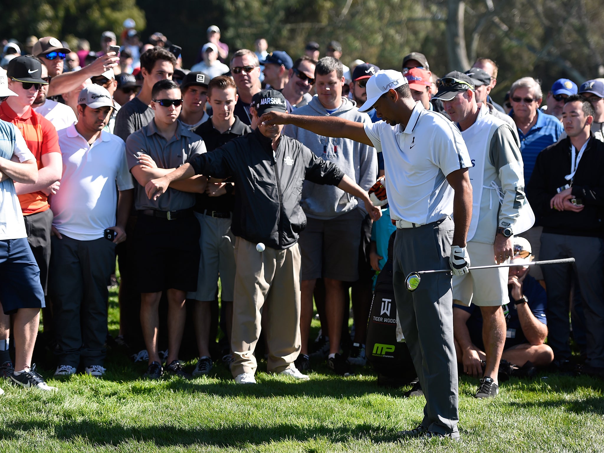 Tiger Woods takes a drop in the rough on the 11th hole of the north course during the first round of the Farmers Insurance Open at Torrey Pines