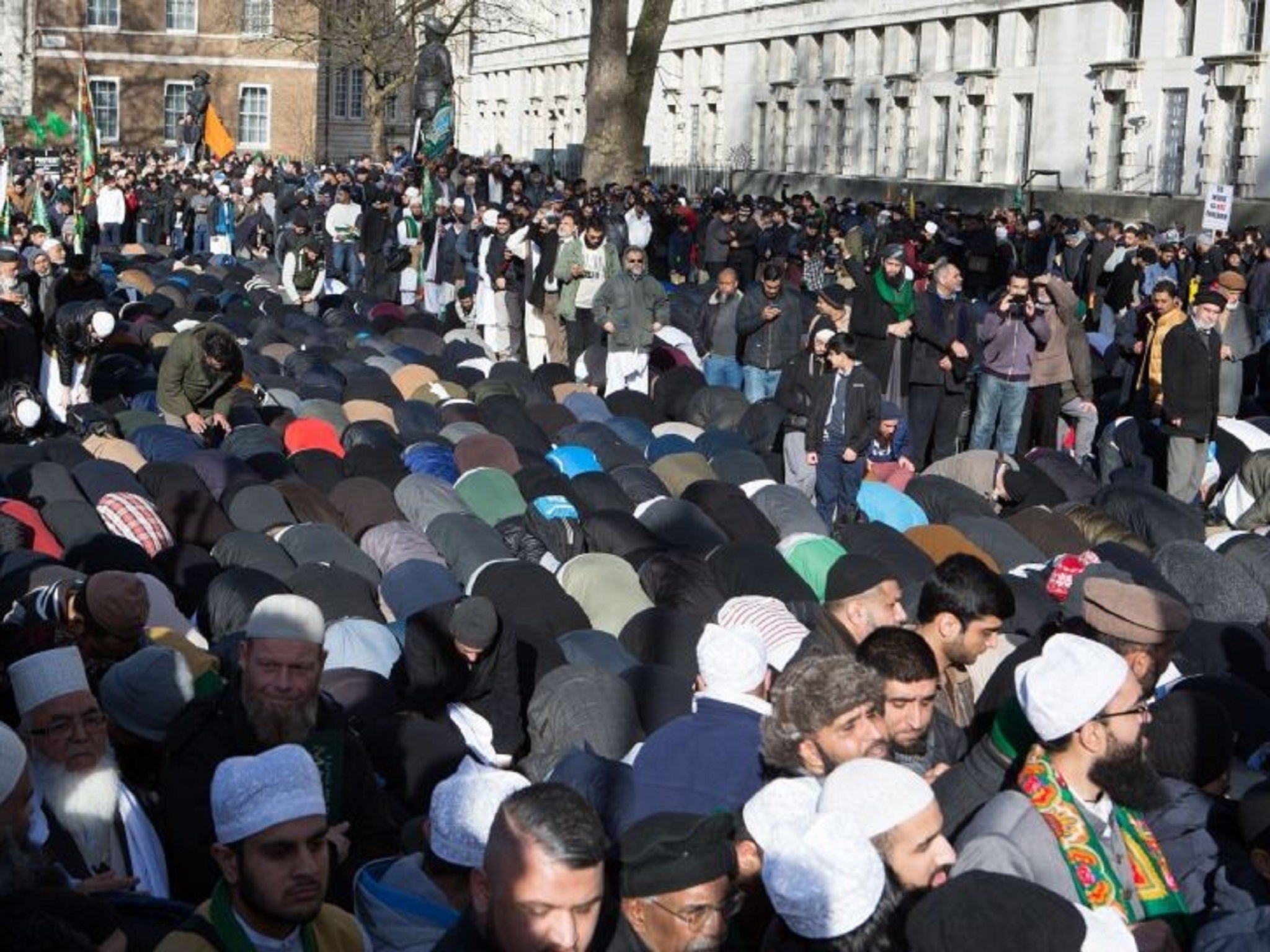 Dozens of Muslims pray on the street during the protest