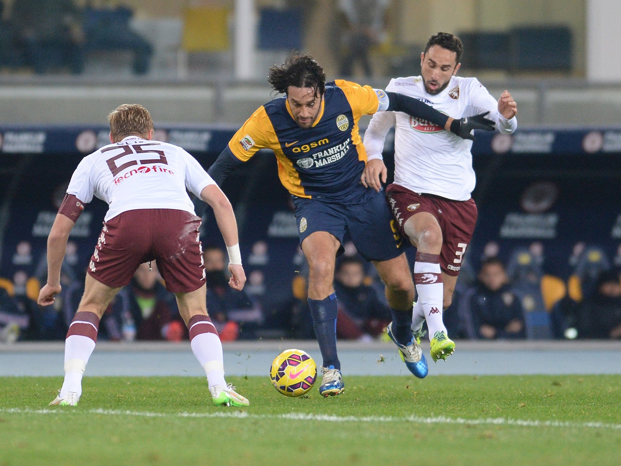 Luca Toni (C) of Hellas Verona competes with Cristian Molinaro (R) and Kamil Glik (L) of Torino