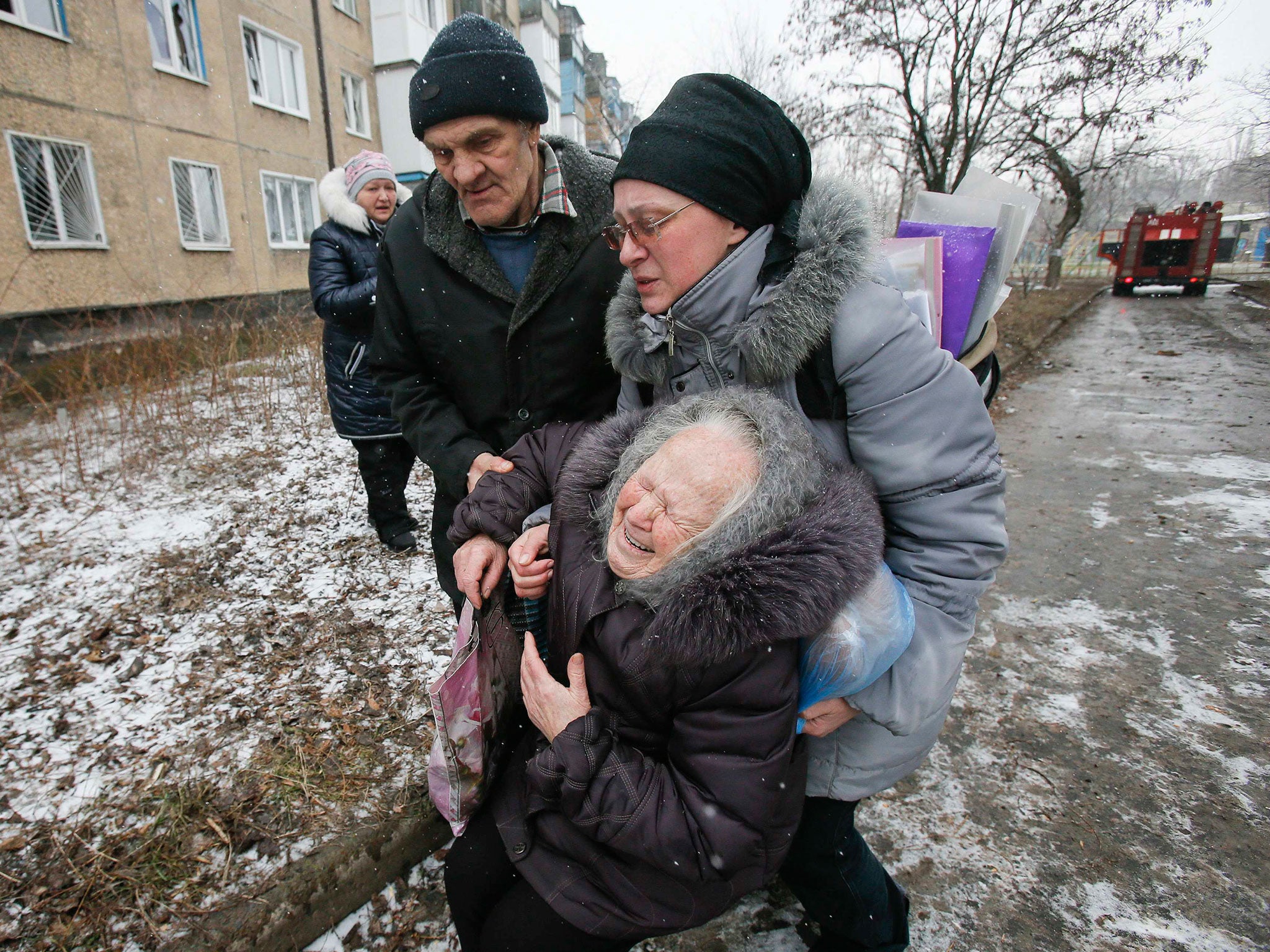 An elderly woman reacts after the residential block in which she lives in was damaged by a recent shelling on the outskirts of Donetsk