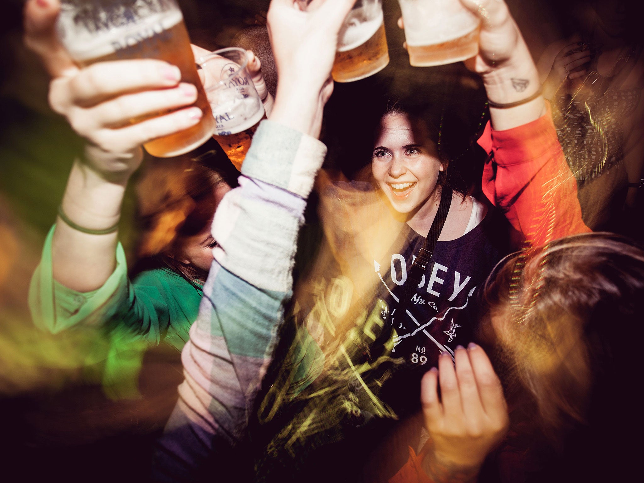 A group of girls saying cheers and are having ice cold drafted beer at the local nightclub.