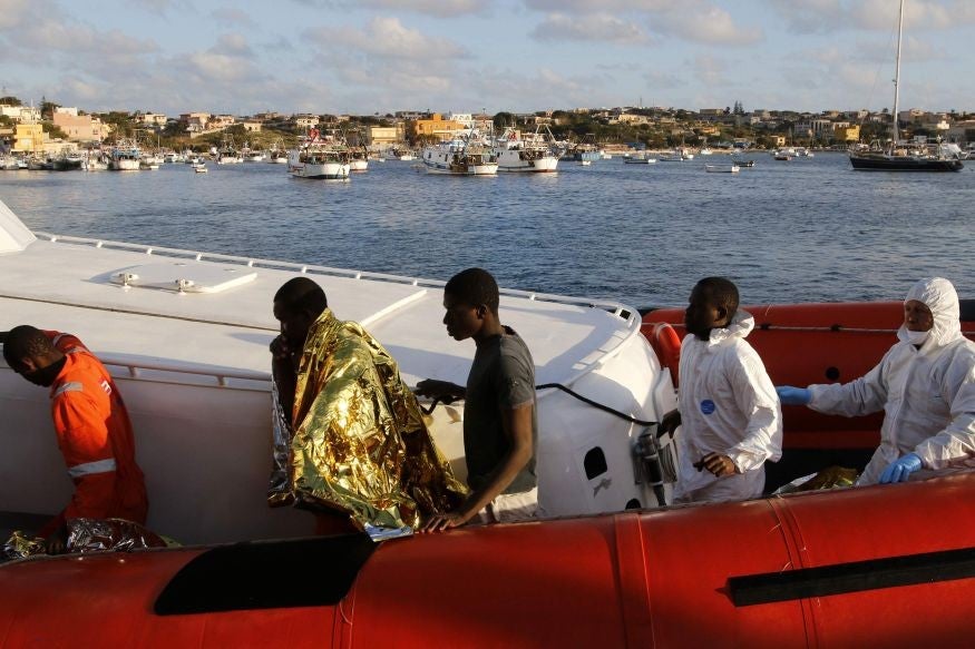 Migrants who survived a shipwreck arrive at the Lampedusa harbour on Wednesday