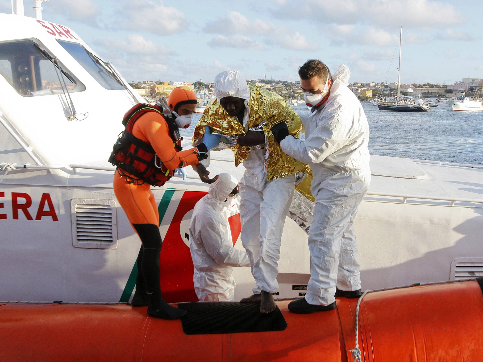 A migrant who survived a shipwreck is helped as he arrives with others at the Lampedusa harbour on Wednesday. An Italian tug boat rescued nine people who had been on two different boats on Monday