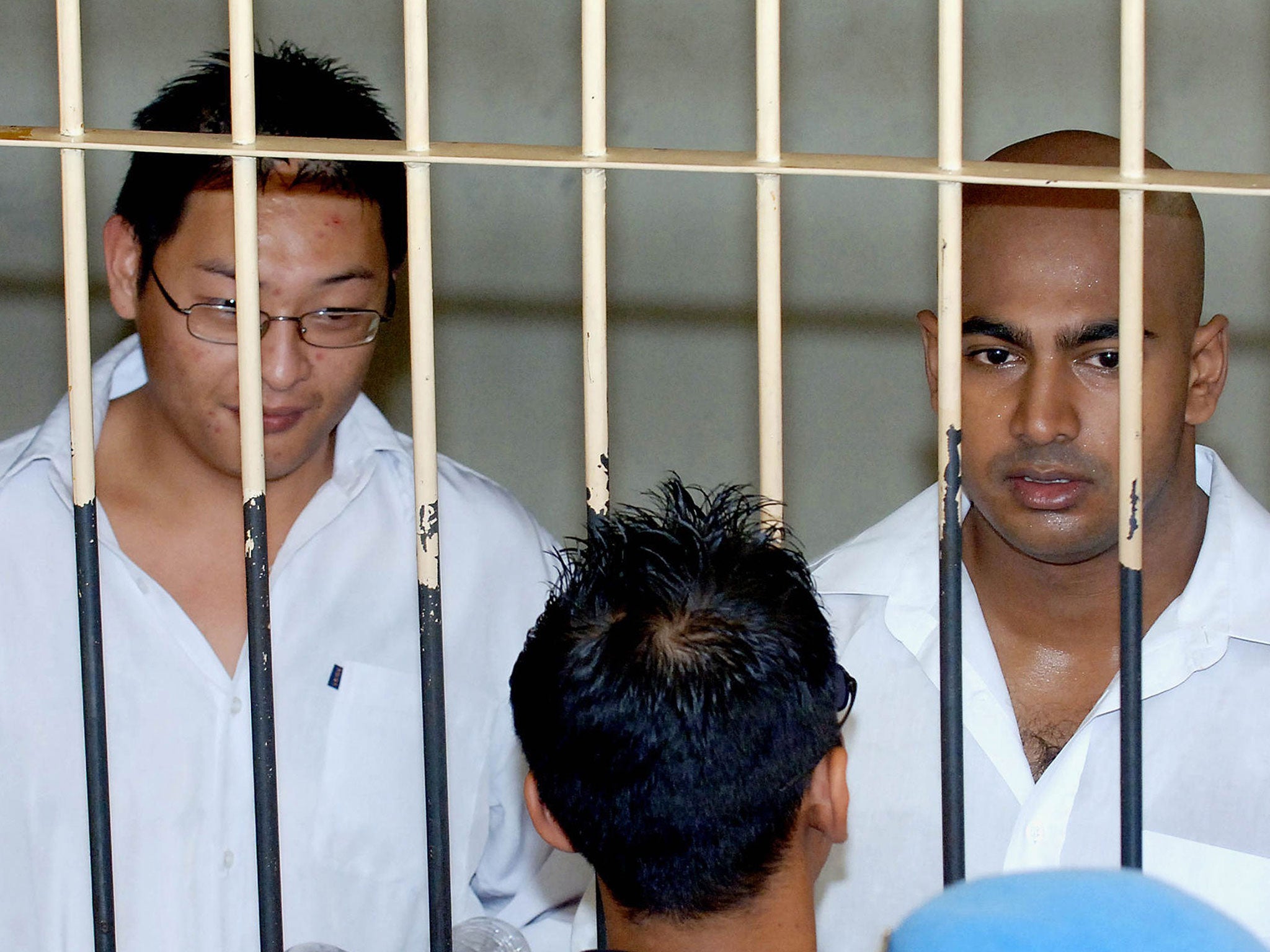 Two Australian drug traffickers Andrew Chan (L) and Myuran Sukumaran (R) the ringleaders of the "Bali Nine" drug ring, are seen in a holding cell while awaiting court trial in Denpasar, on Bali island