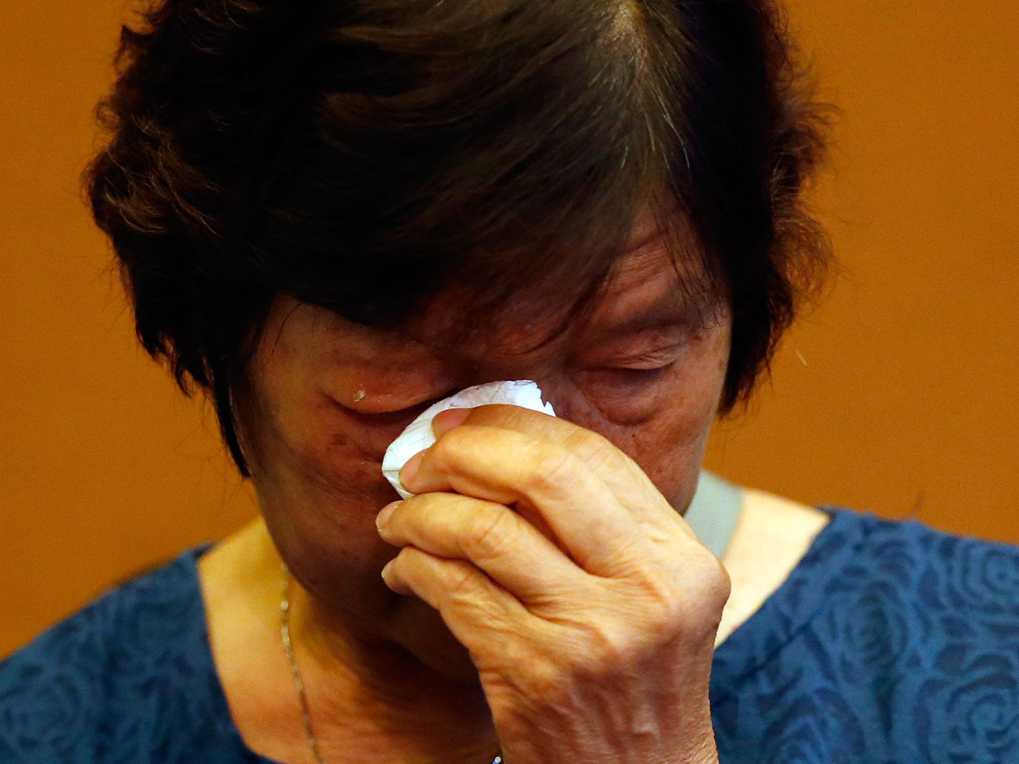 Halen Chan, the mother of death-row prisoner Andrew Chan, wipes away tears during a press conference in Jakarta, Indonesia