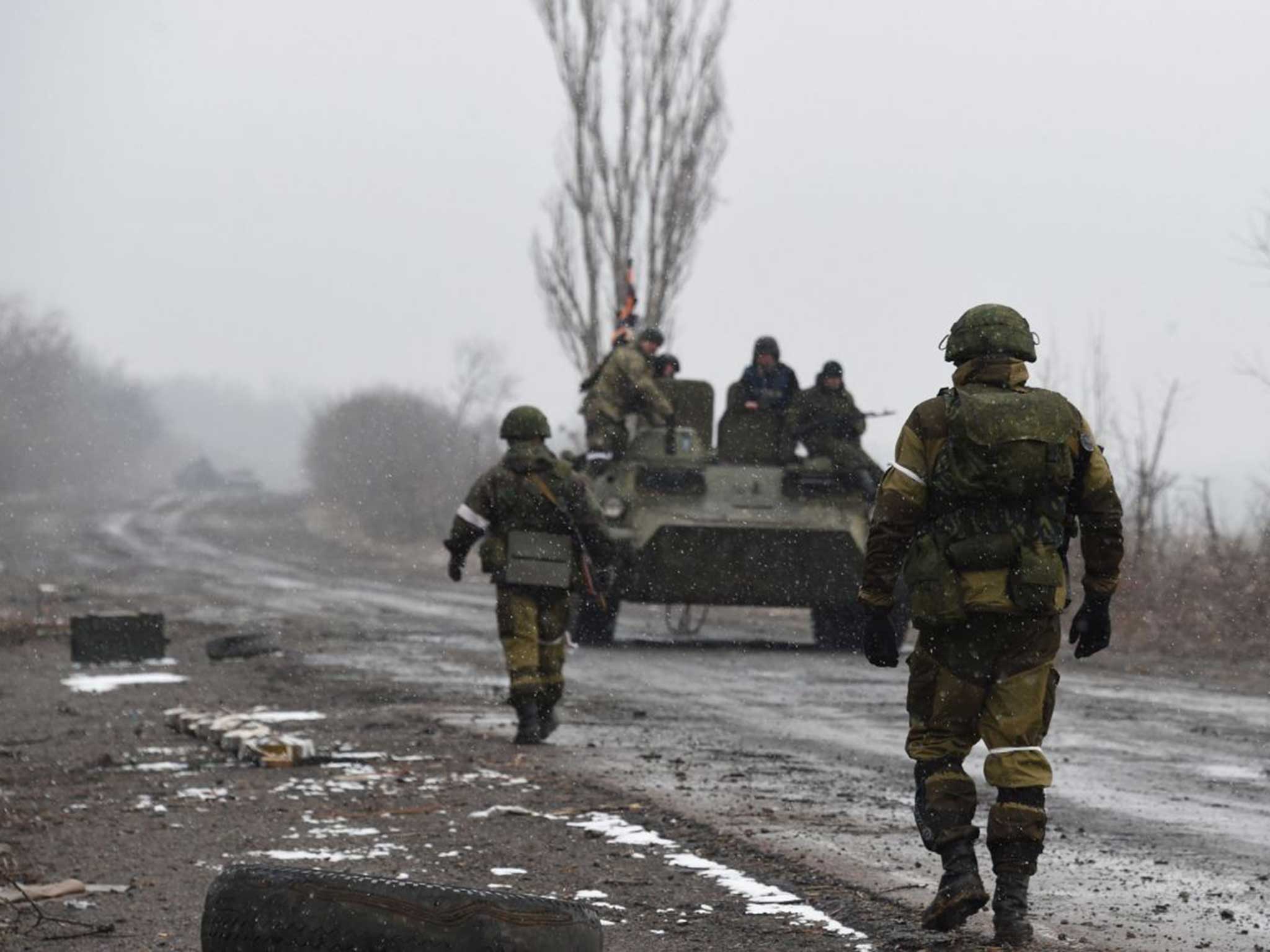 Pro-Russian soldiers walk along a road near contested town of Debaltseve earlier in February