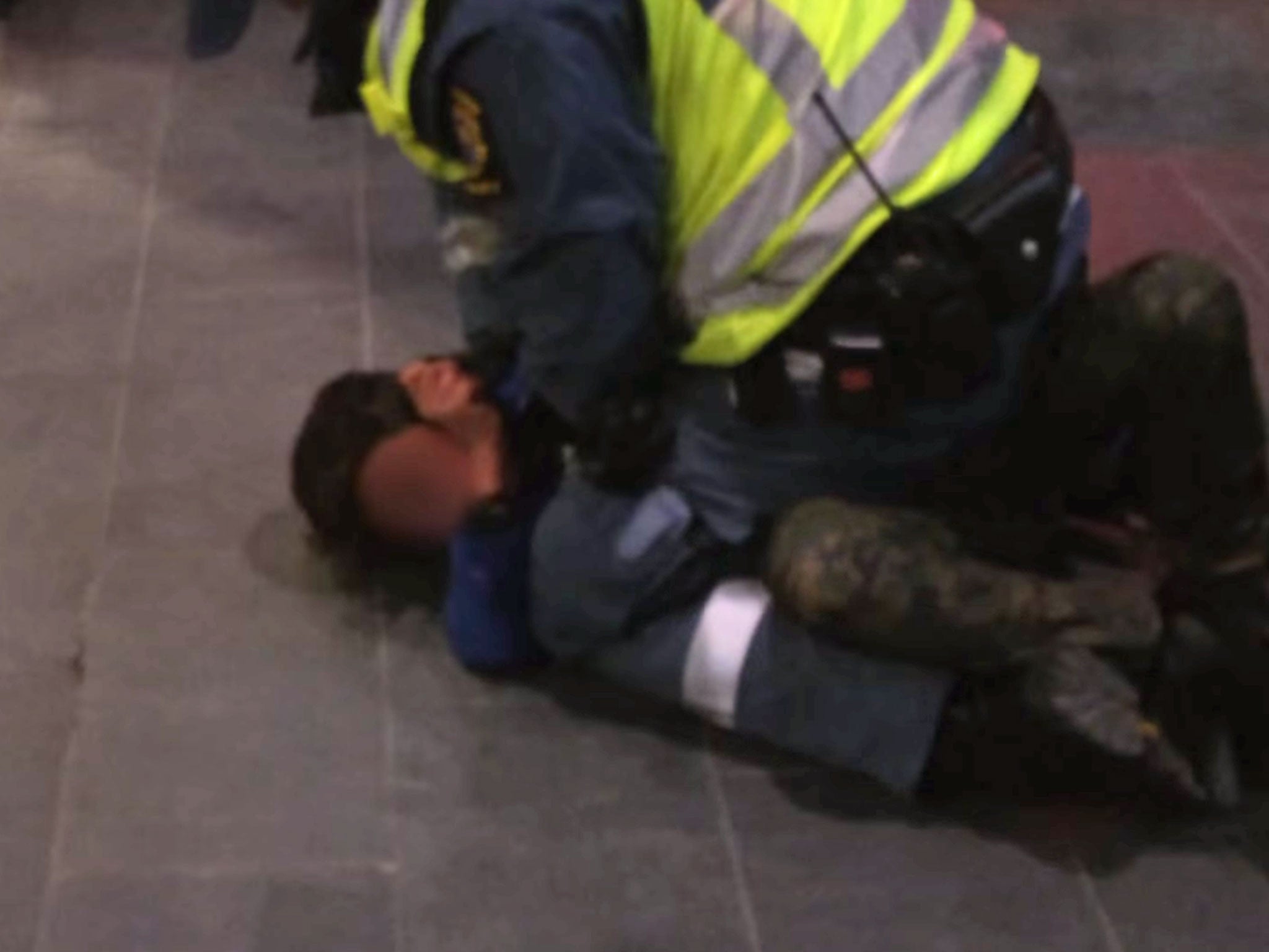 A nine-year-old boy being held down by a train station security guard