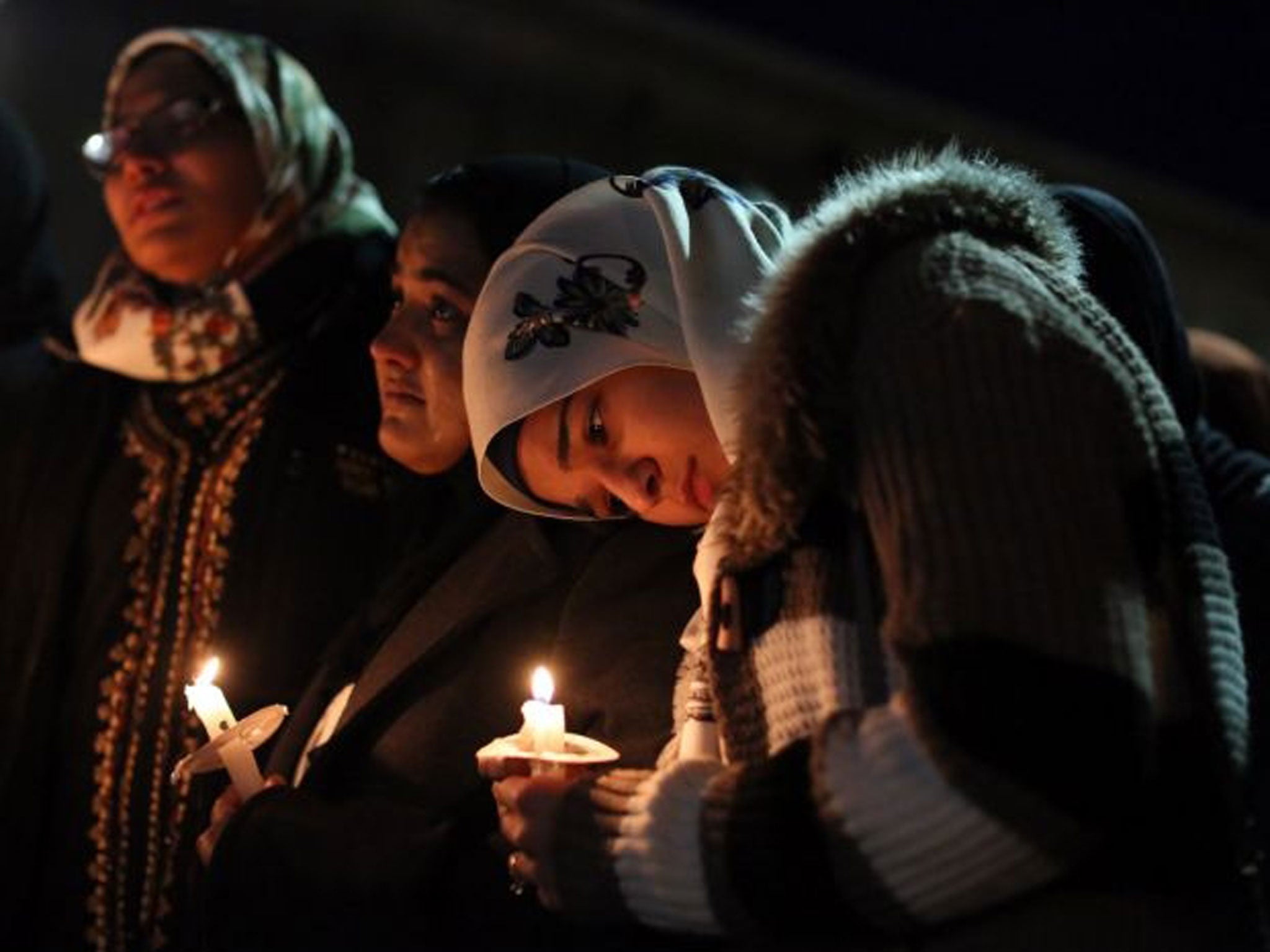 Suzanne Askar, right, rests her head on the shoulder of Safam Mahate, a student at North Carolina State University, as they stand next to Nida Allam, far left, during the vigil (Getty Images)