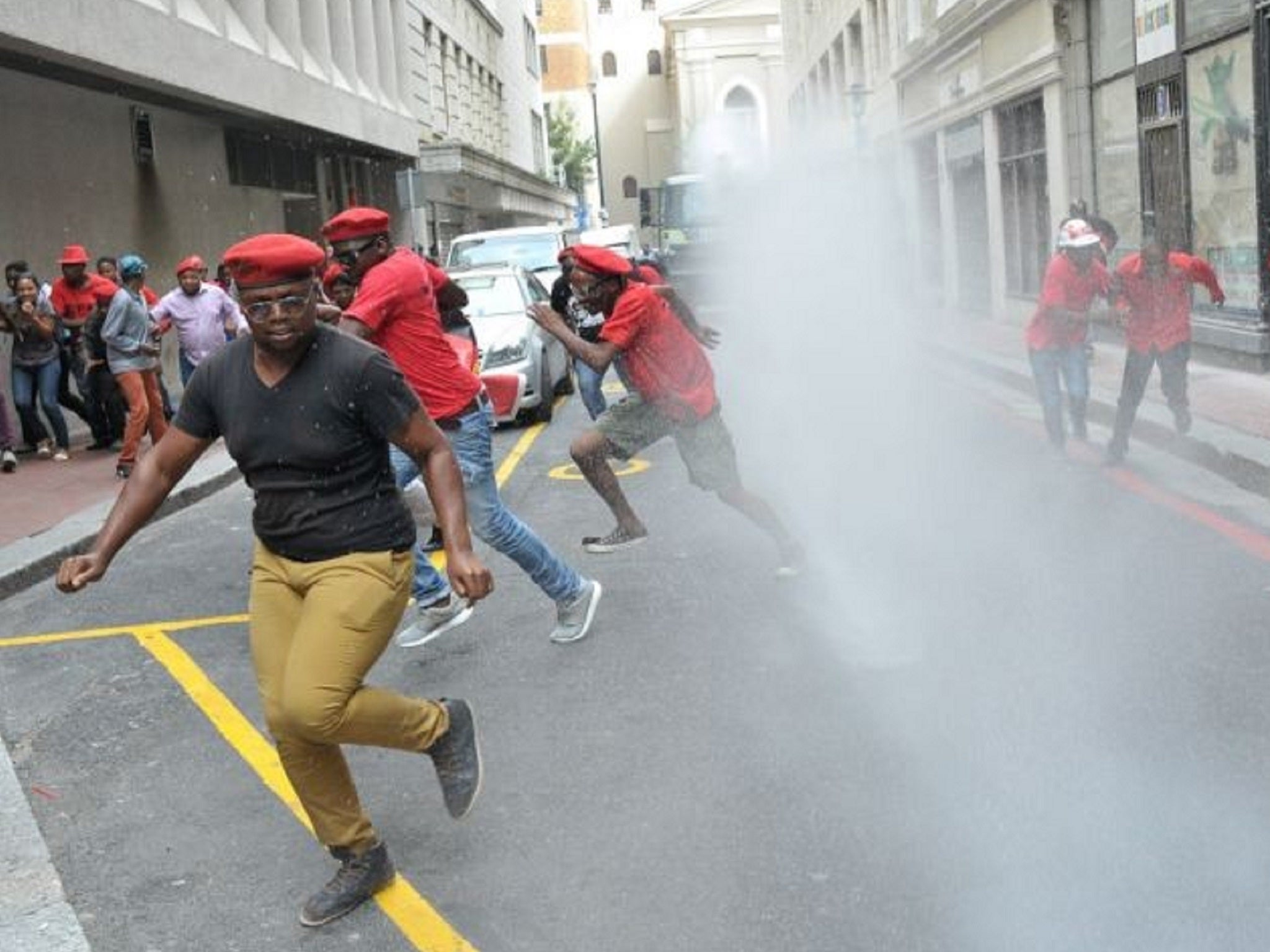 Protesters run from water cannon used by riot police