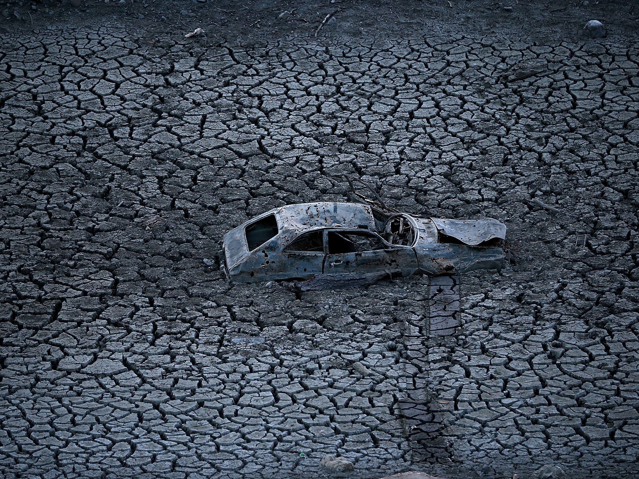 Long dry season: a car sits in the parched, cracked earth of the Almaden Reservoir