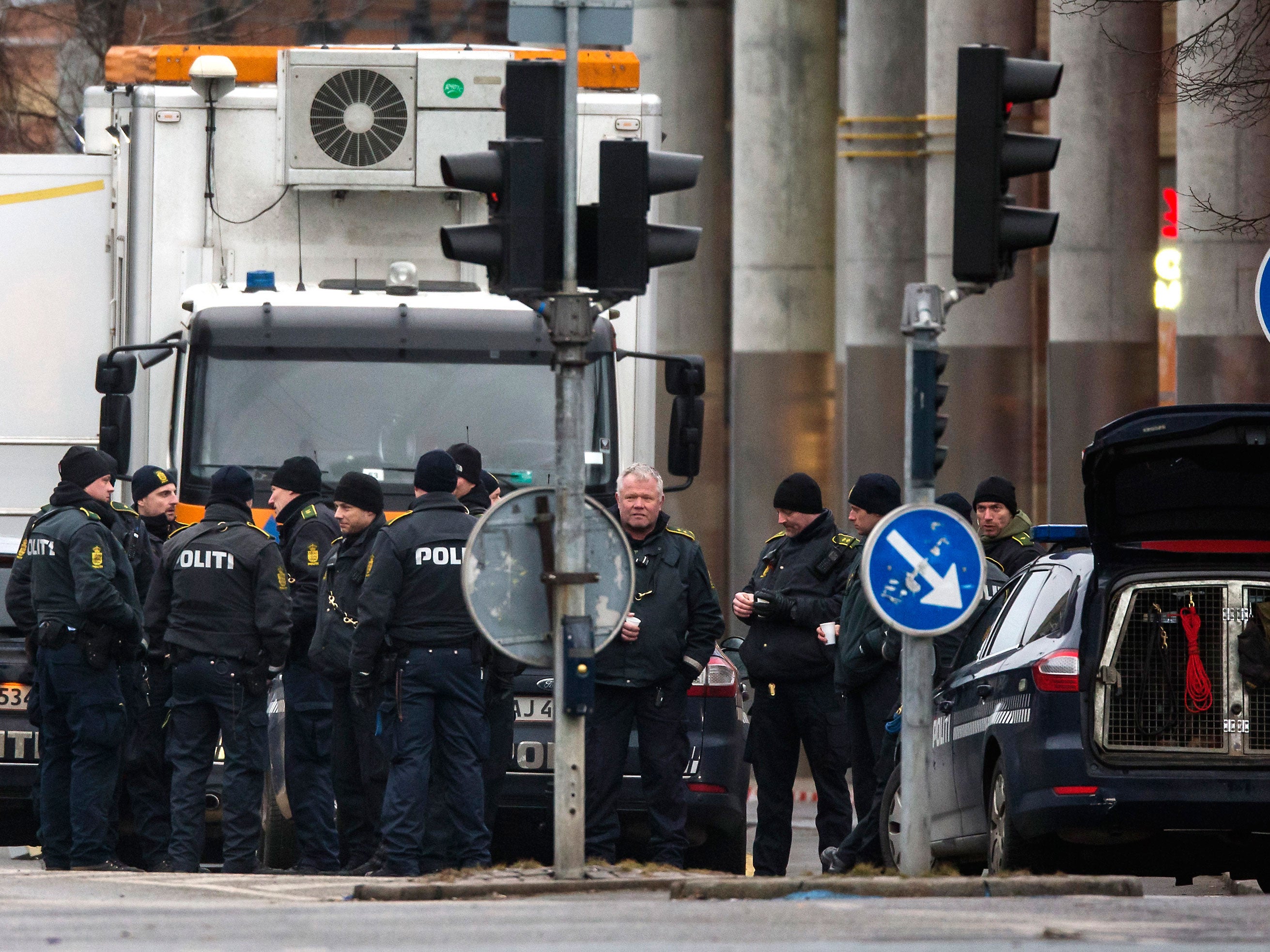 Police officers gather near the site where a man was killed by police, close to Norrebro Station