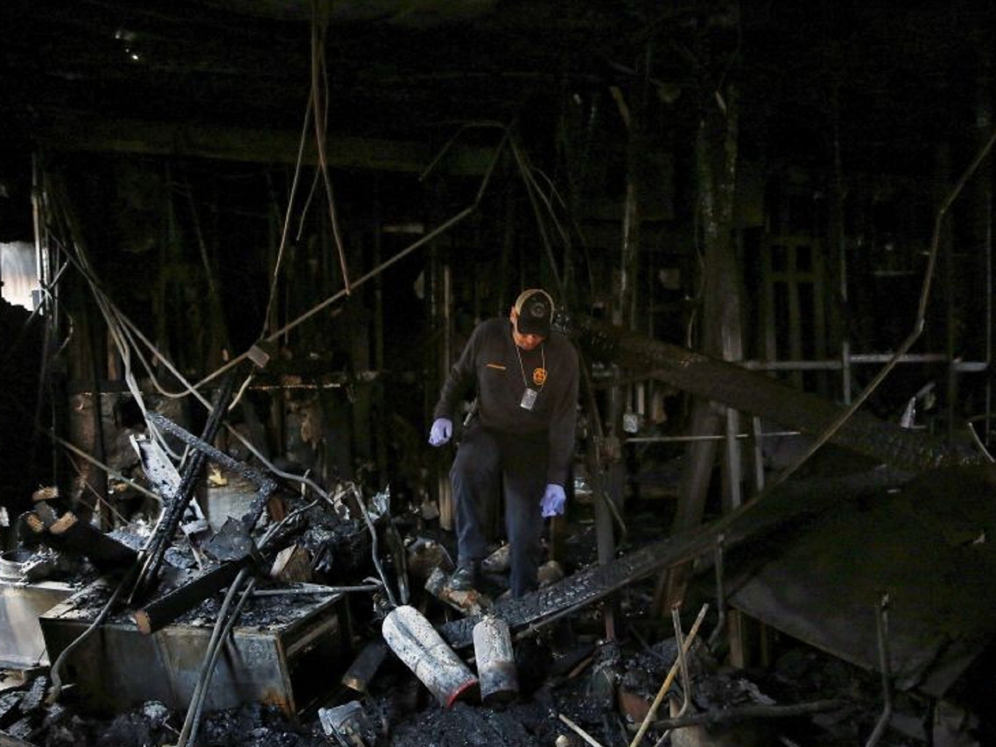 A Houston Fire Department investigator inspects the charred scene